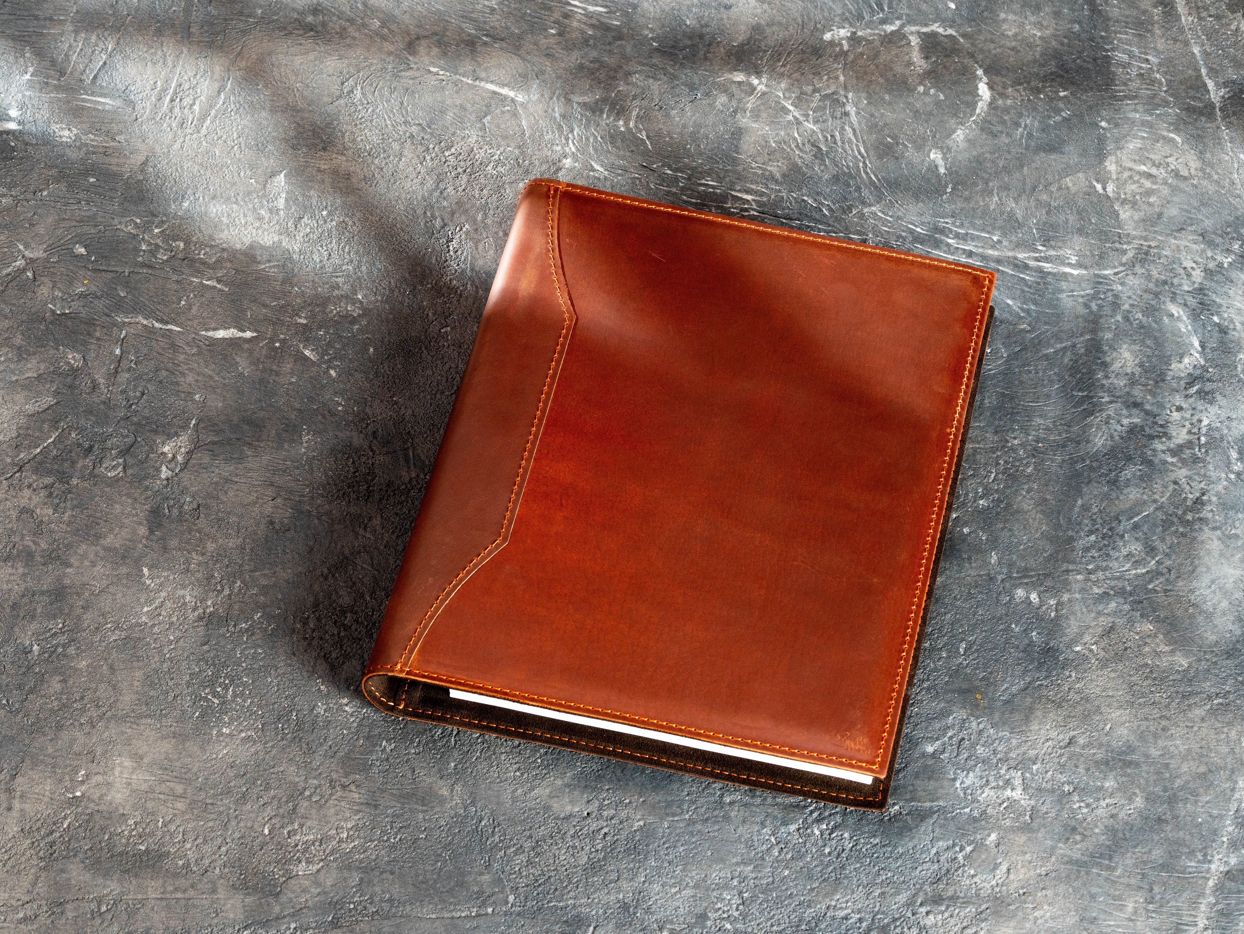 Back view of a copper Crazy Horse leather 3-ring binder with distinctive stitched spine-side design