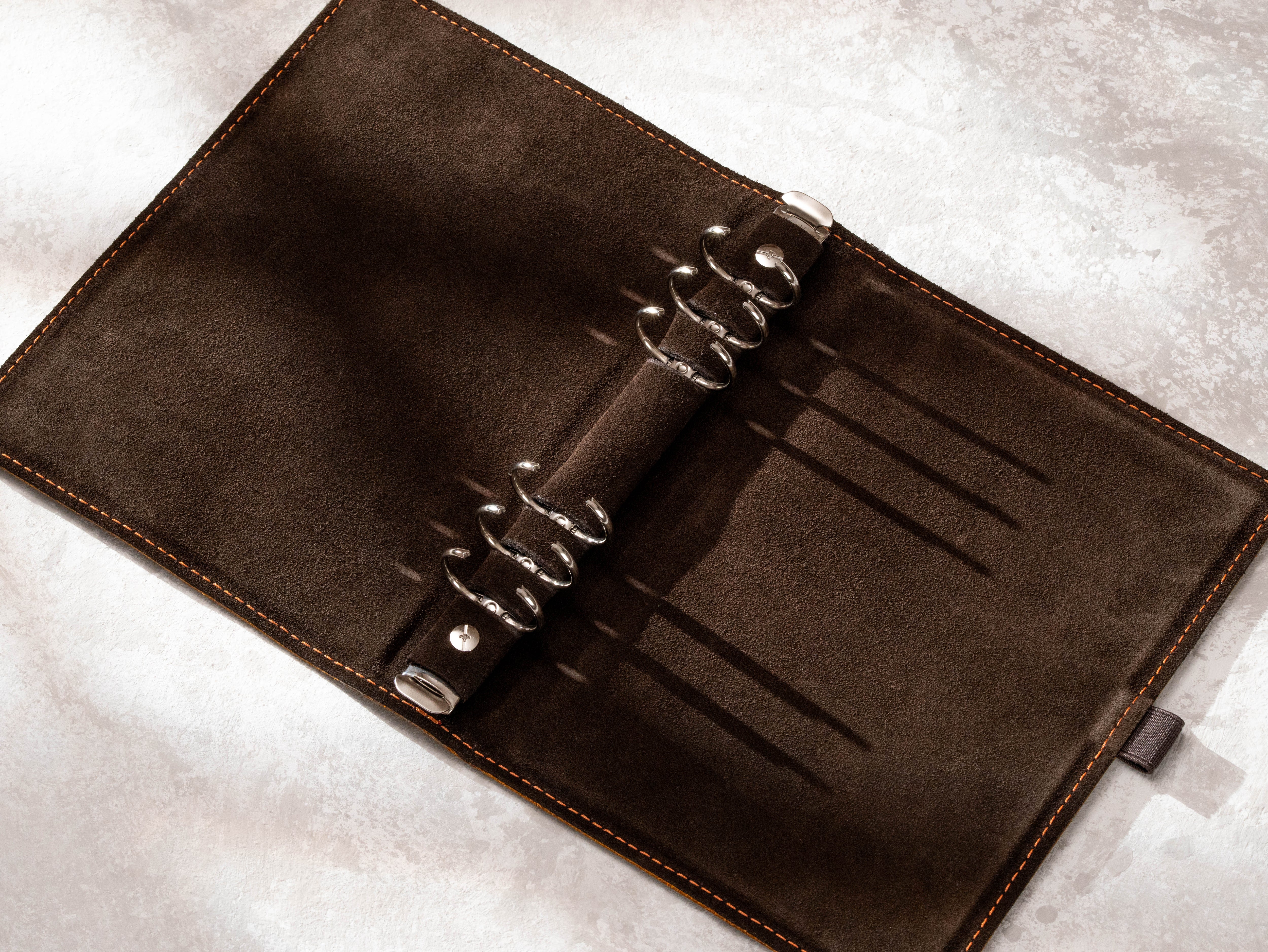 Open leather recipe organizer showing 6-ring refill binder mechanism and suede interior
