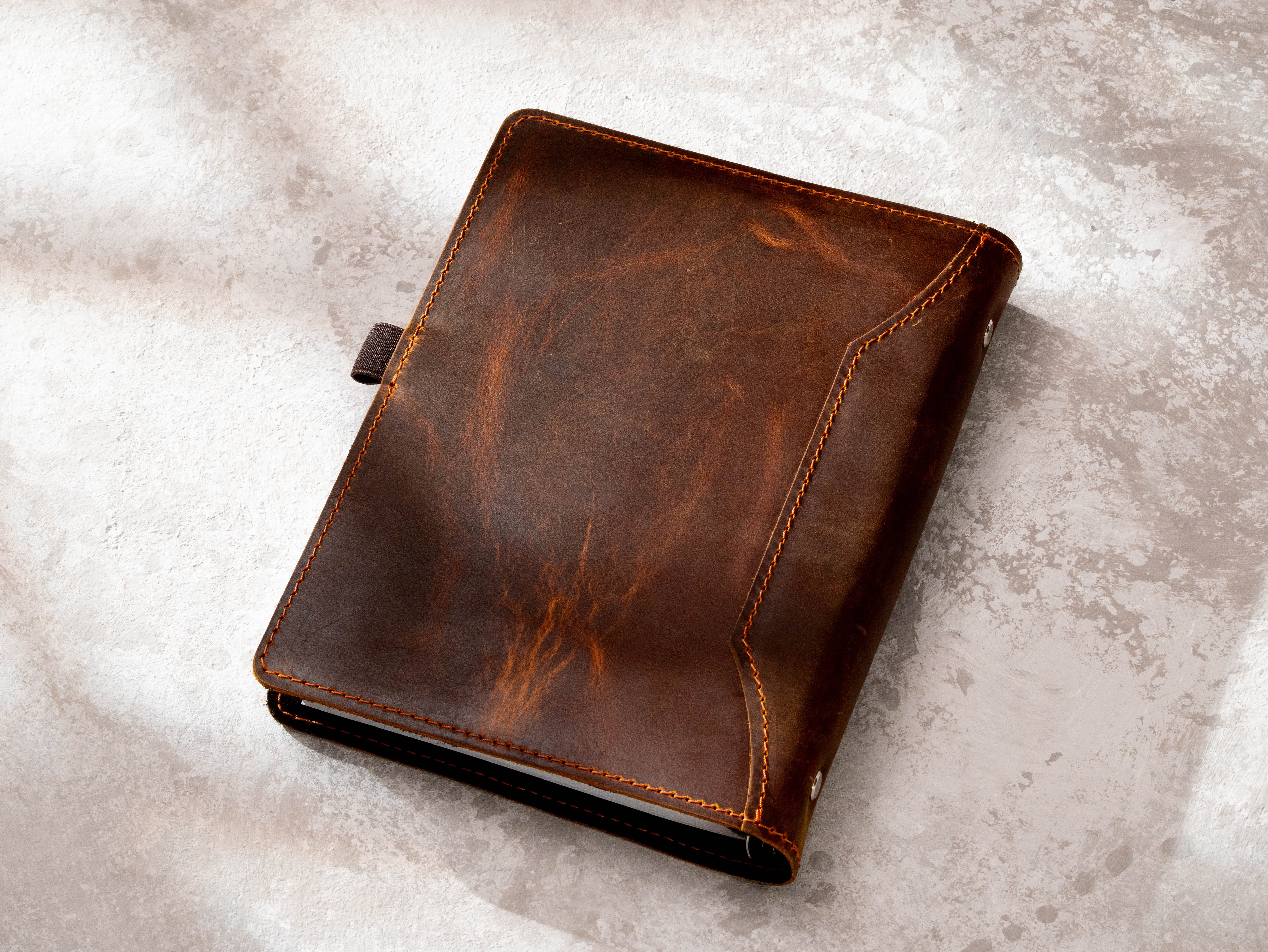 Back view of chestnut leather A5 recipe binder showing natural leather texture, stitching and structured cover