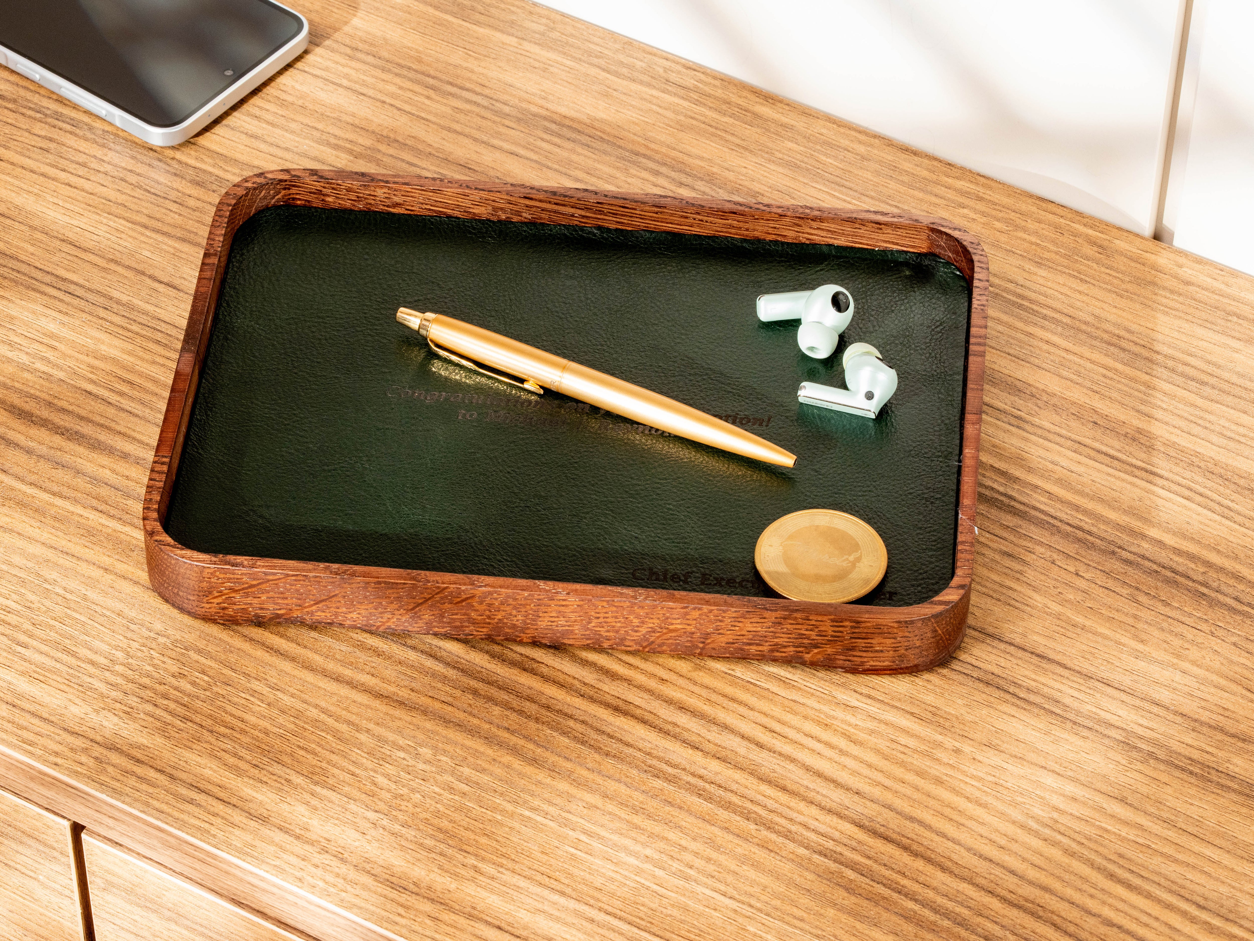 Personalized oak wood valet tray with forest green leather insert, pen, earbuds and custom engraving