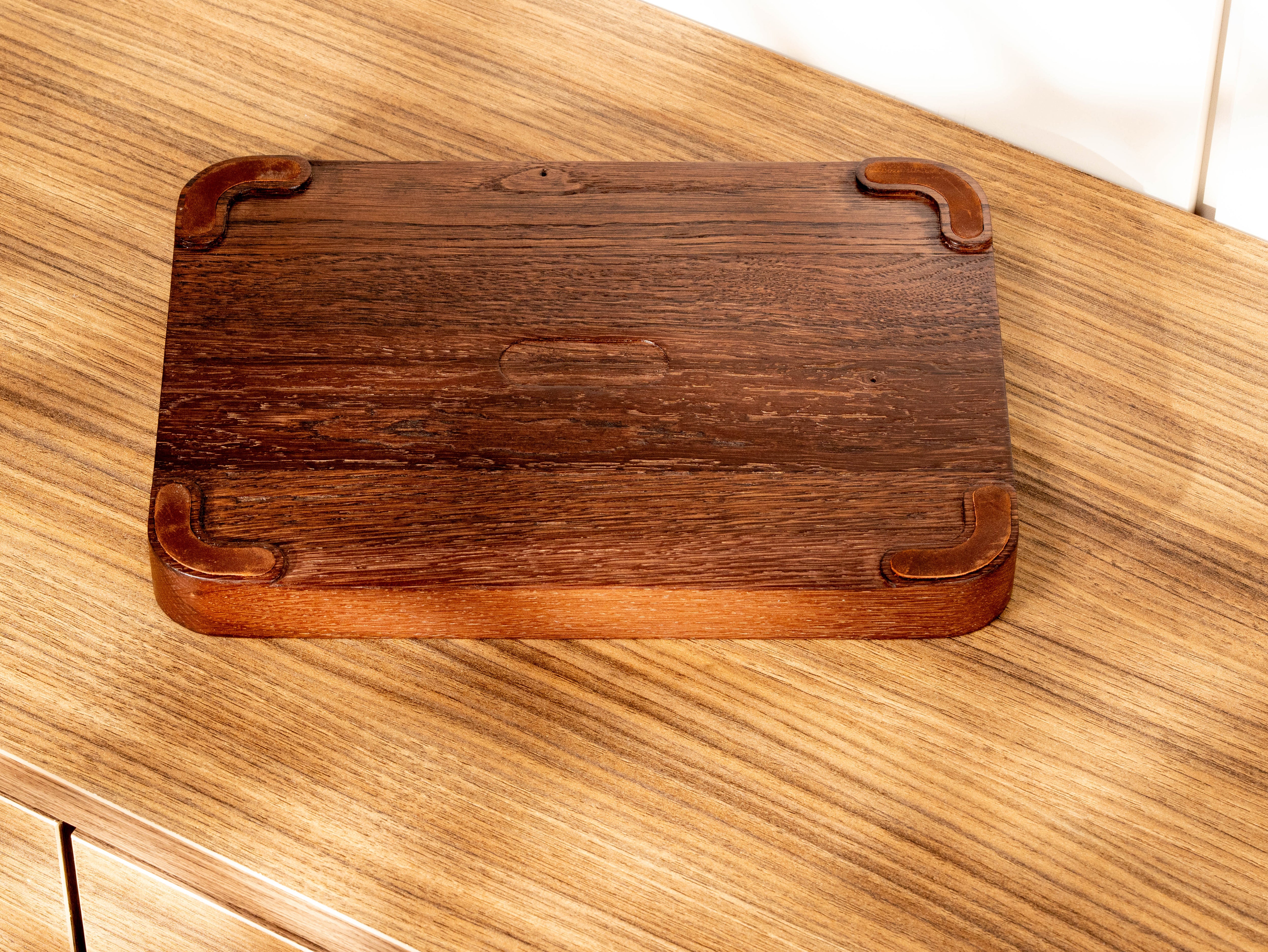 Bottom view of oak wood valet tray showing recessed leather feet designed for stability and surface protection.
