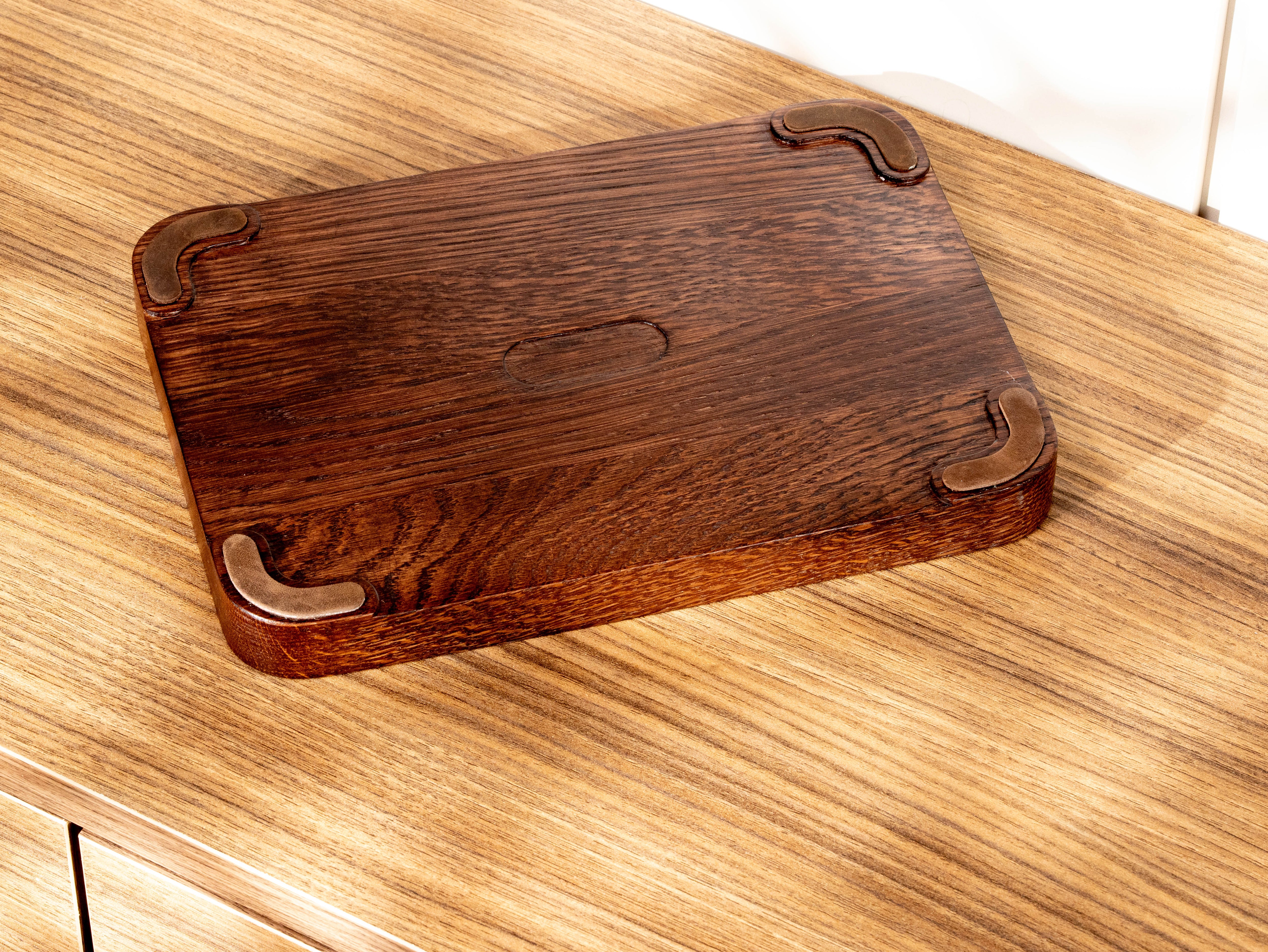 Bottom view of oak wood valet tray with fitted dark brown leather anti-slip feet recessed into the wooden base.