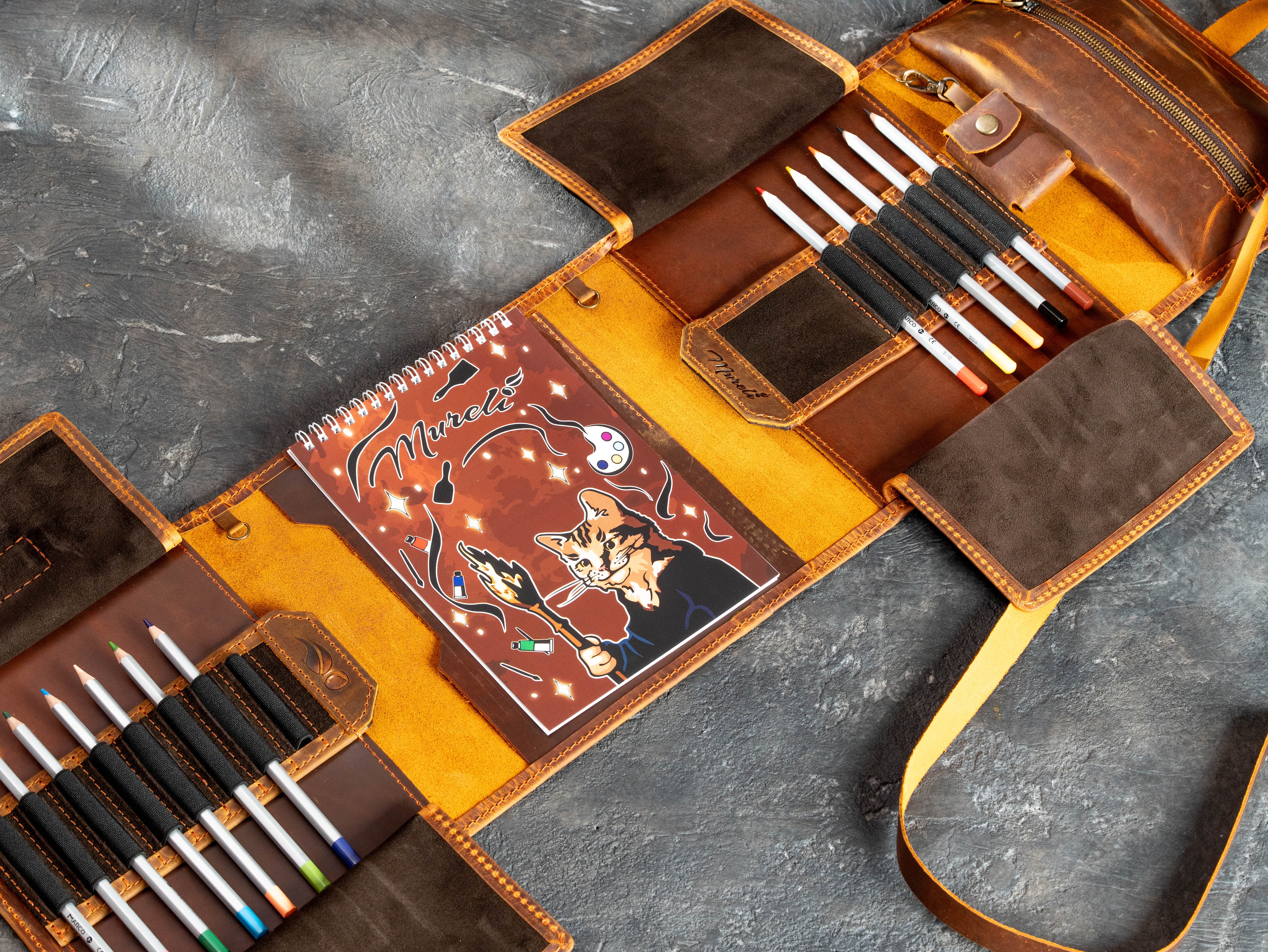 Open artist organizer with A5 sketchbook, 12 colored pencils, removable leather pencil case, and wrap strap