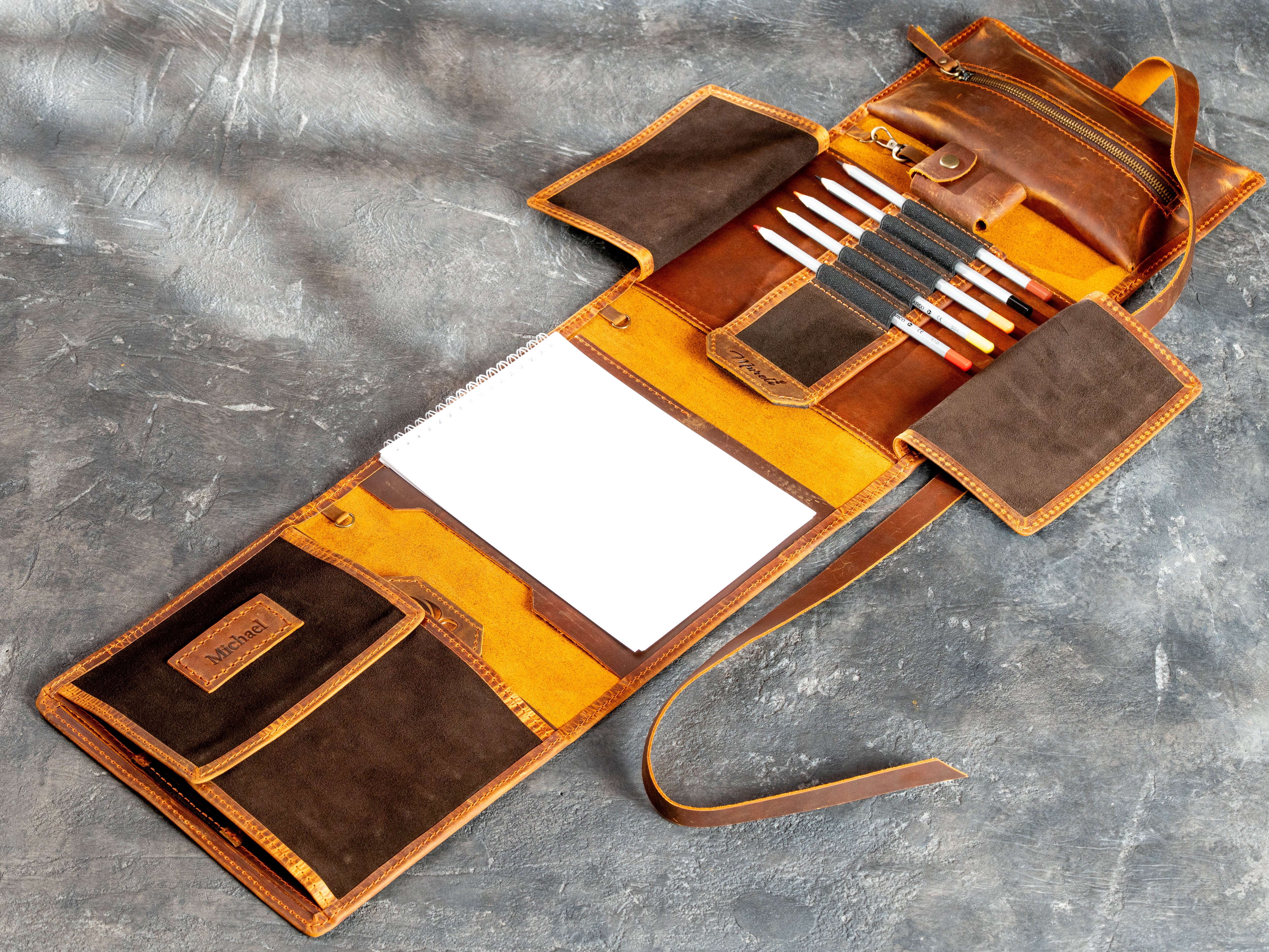 Fully opened leather drawing organizer with A5 sketchbook, 12 pencils, zipper pouch, removable case, and suede pockets
