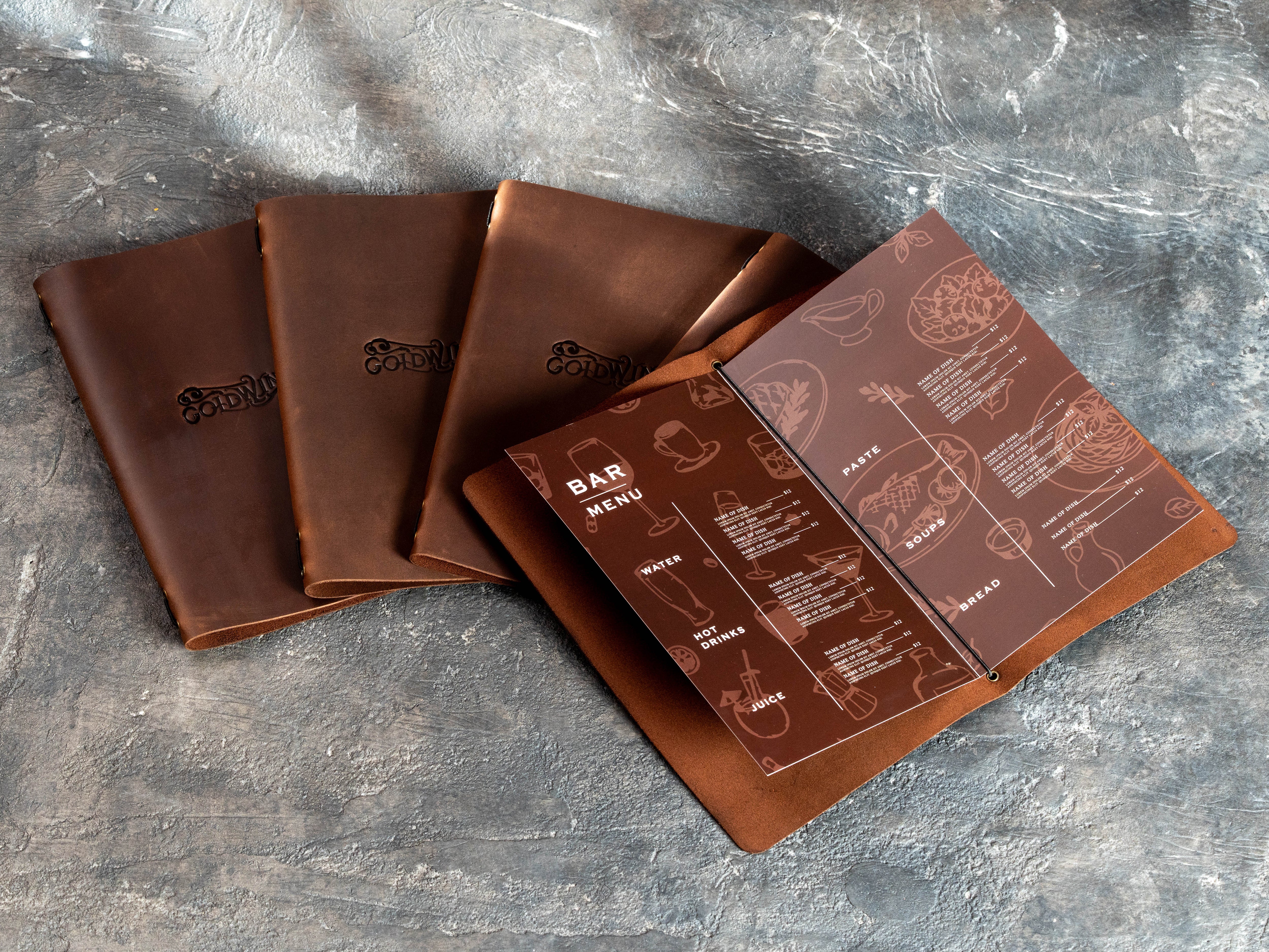 Open brown leather bar menu folder holding a folded Letter Size menu with elastic cord binding