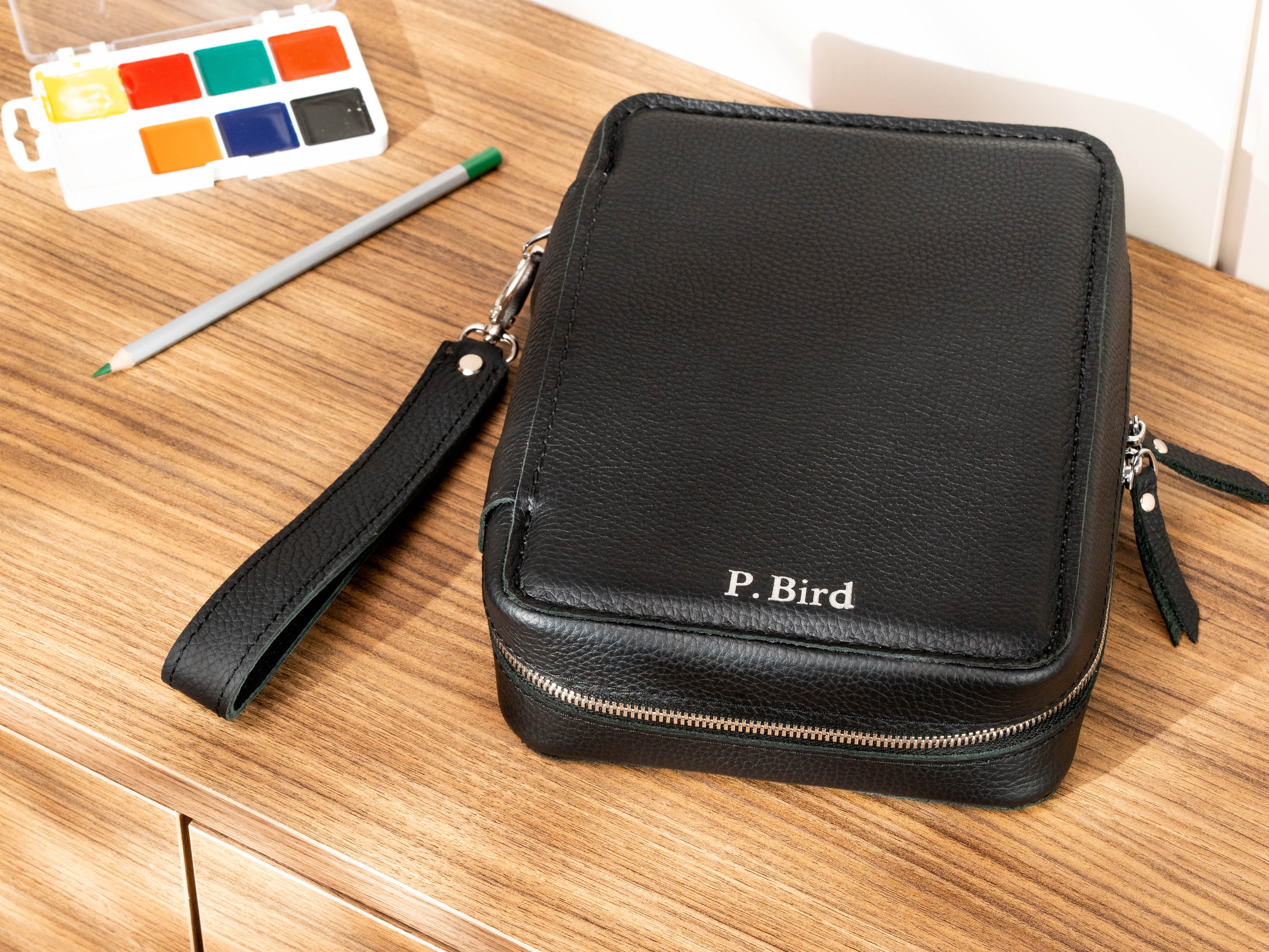 Personalized black leather artist organizer with P. Bird name, zipper closure and detachable wrist strap