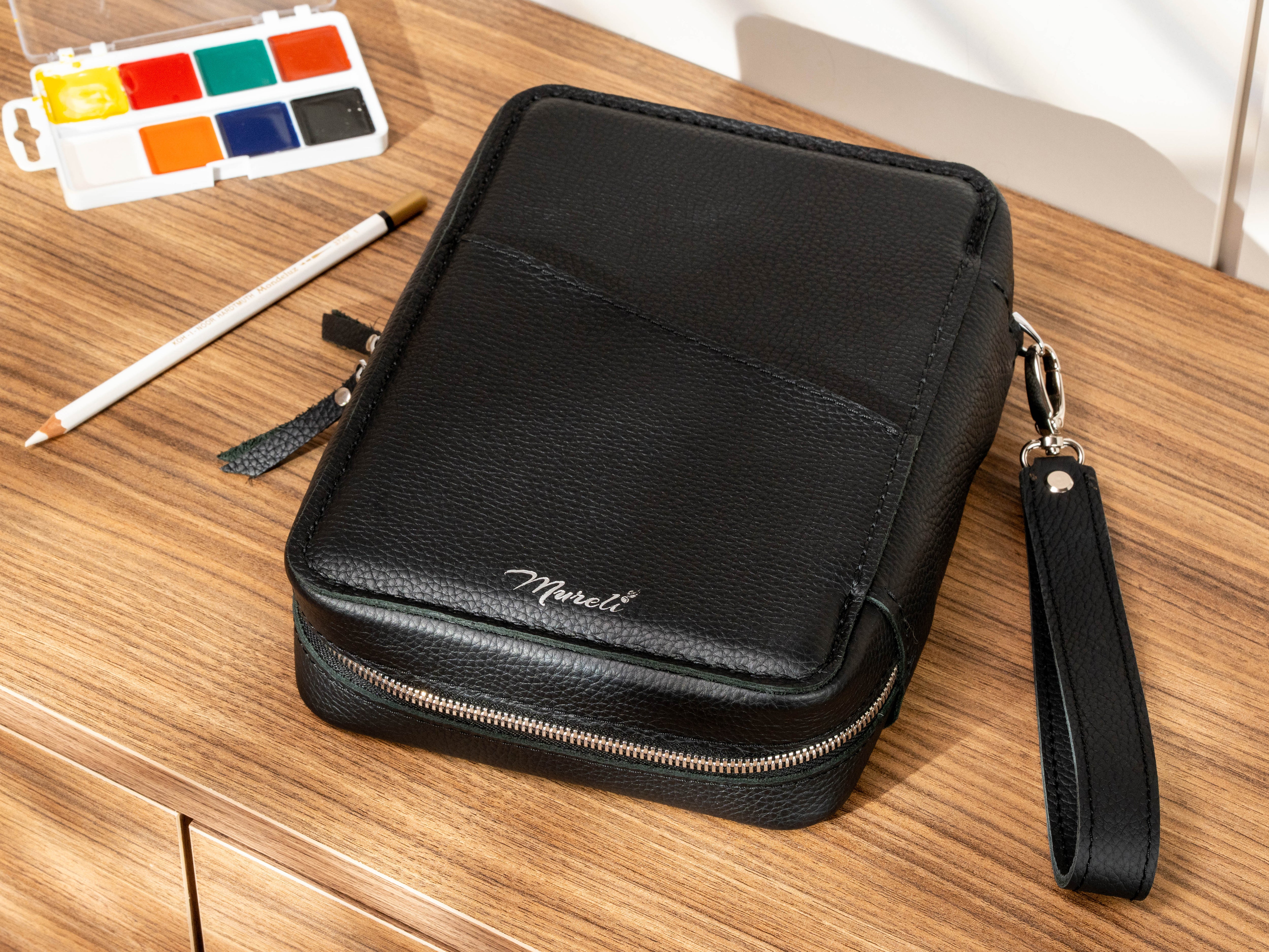 Black Floater leather travel art case with exterior storage pocket, zipper closure and wrist strap