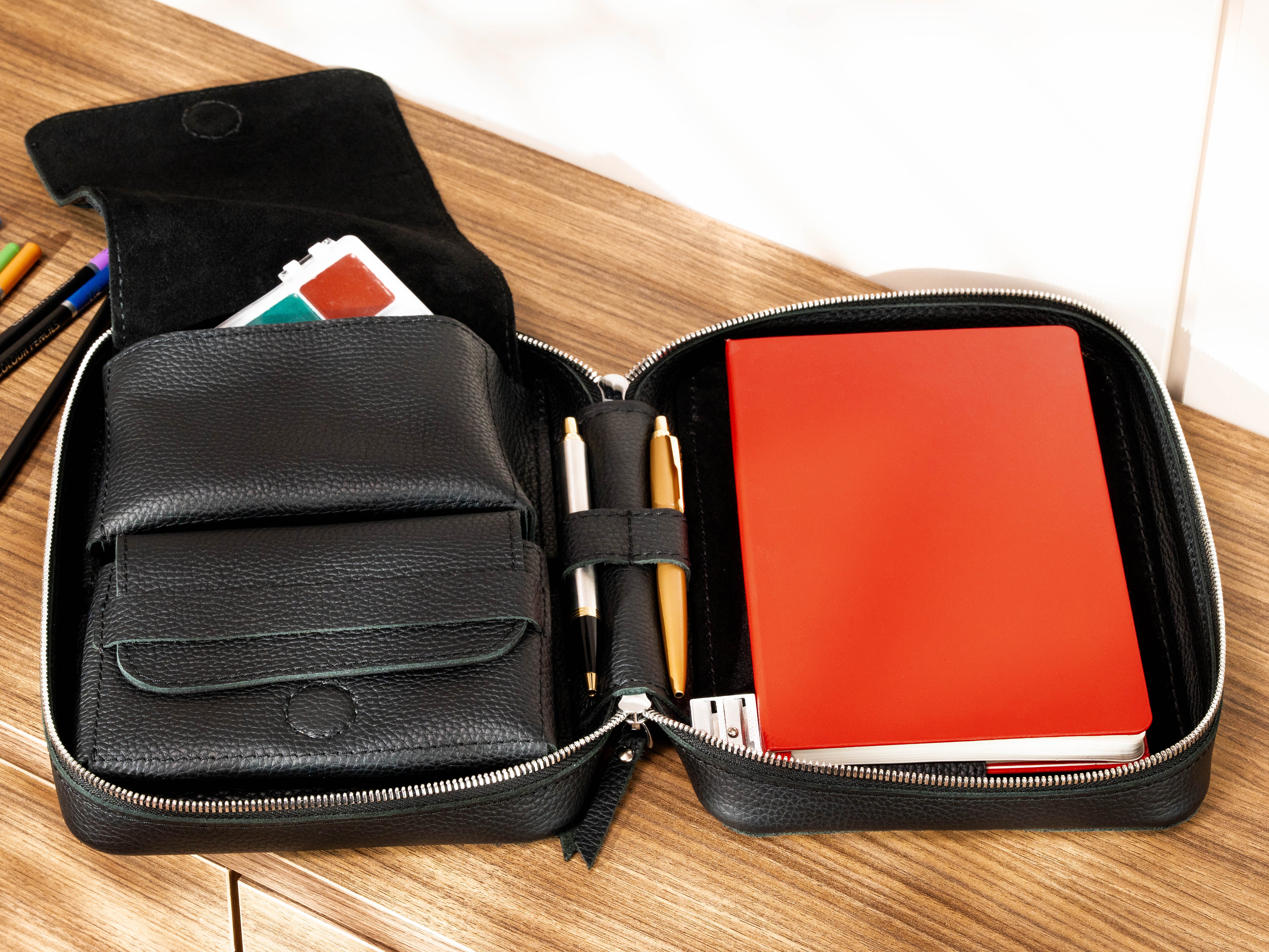 Black leather artist organizer with A5 sketchbook, watercolor supplies, storage pouches and pen holders