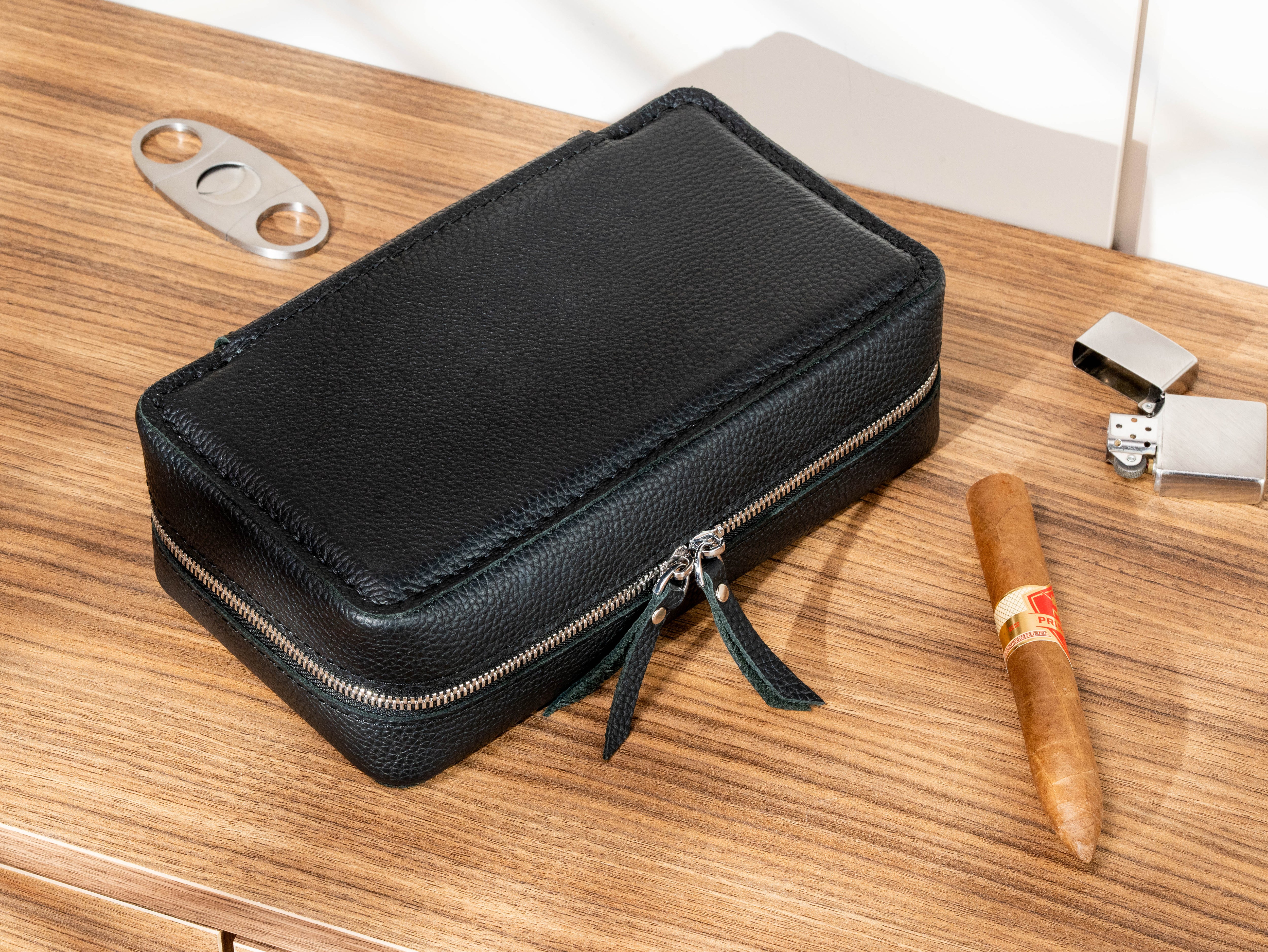 Black Floater leather cigar travel case shown with cigar cutter, lighter and cigar accessories
