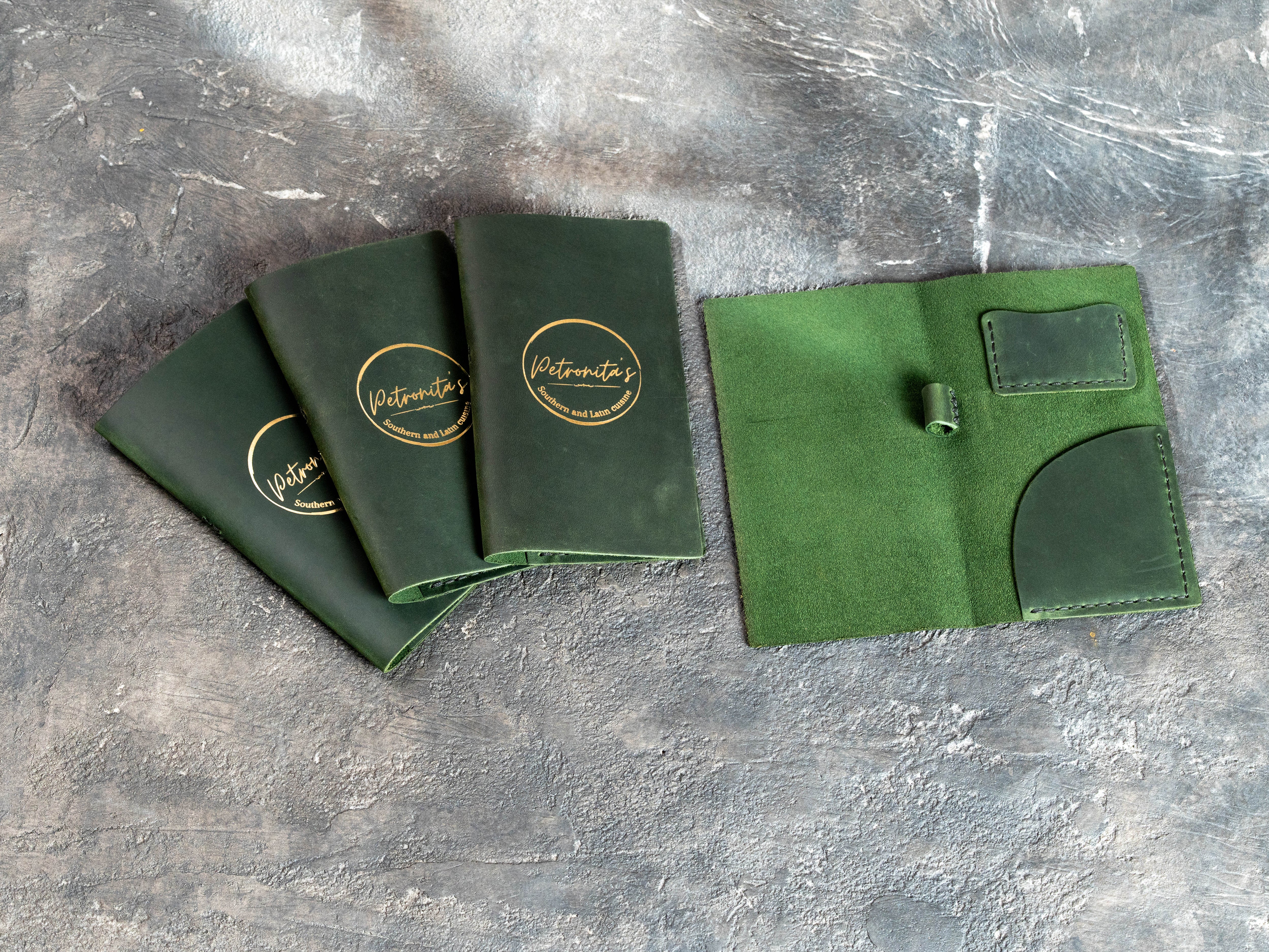 Green leather bill holders beside an open Design #6 check presenter interior