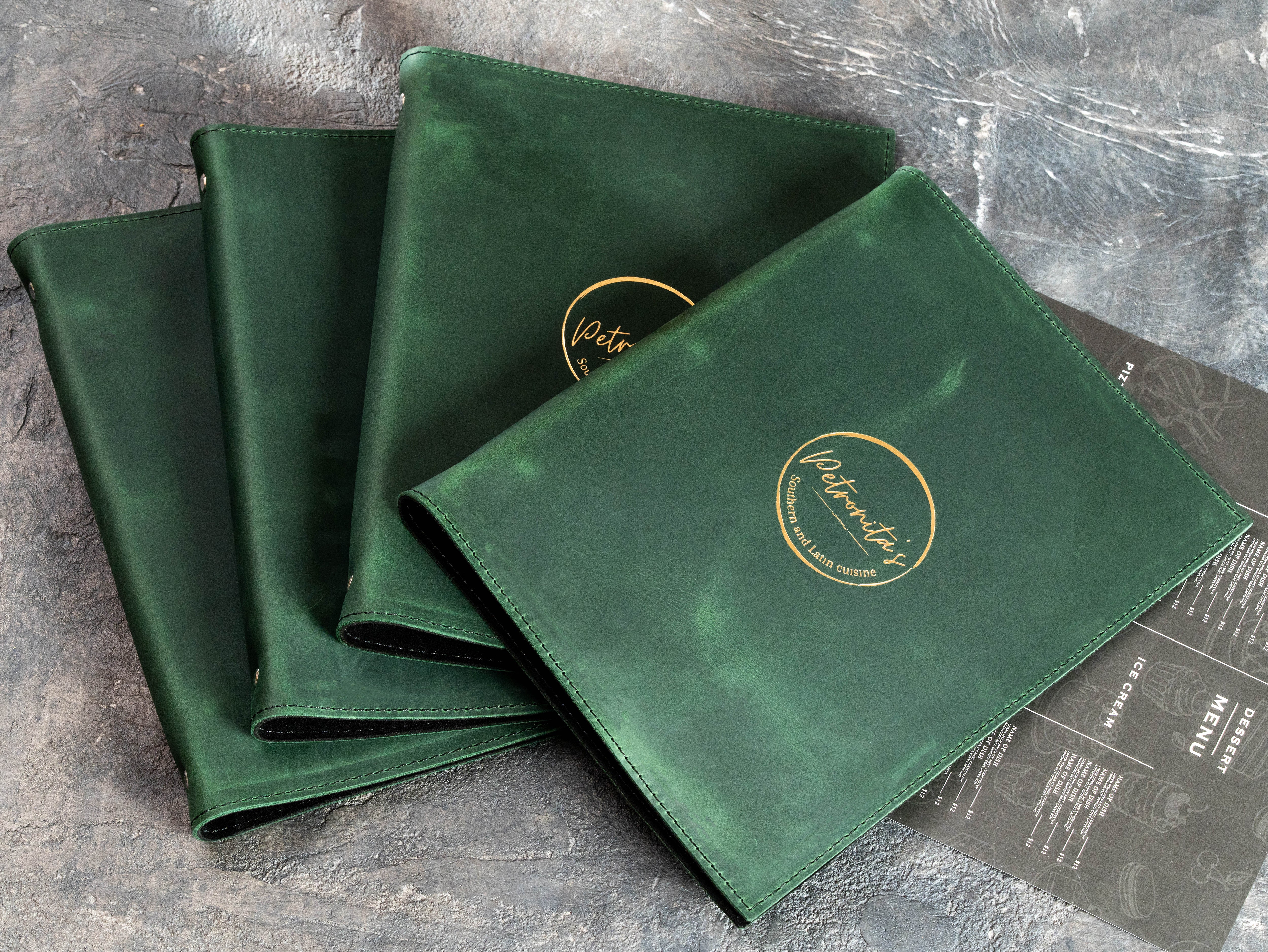 Green Crazy Horse leather menu binders with custom gold restaurant branding