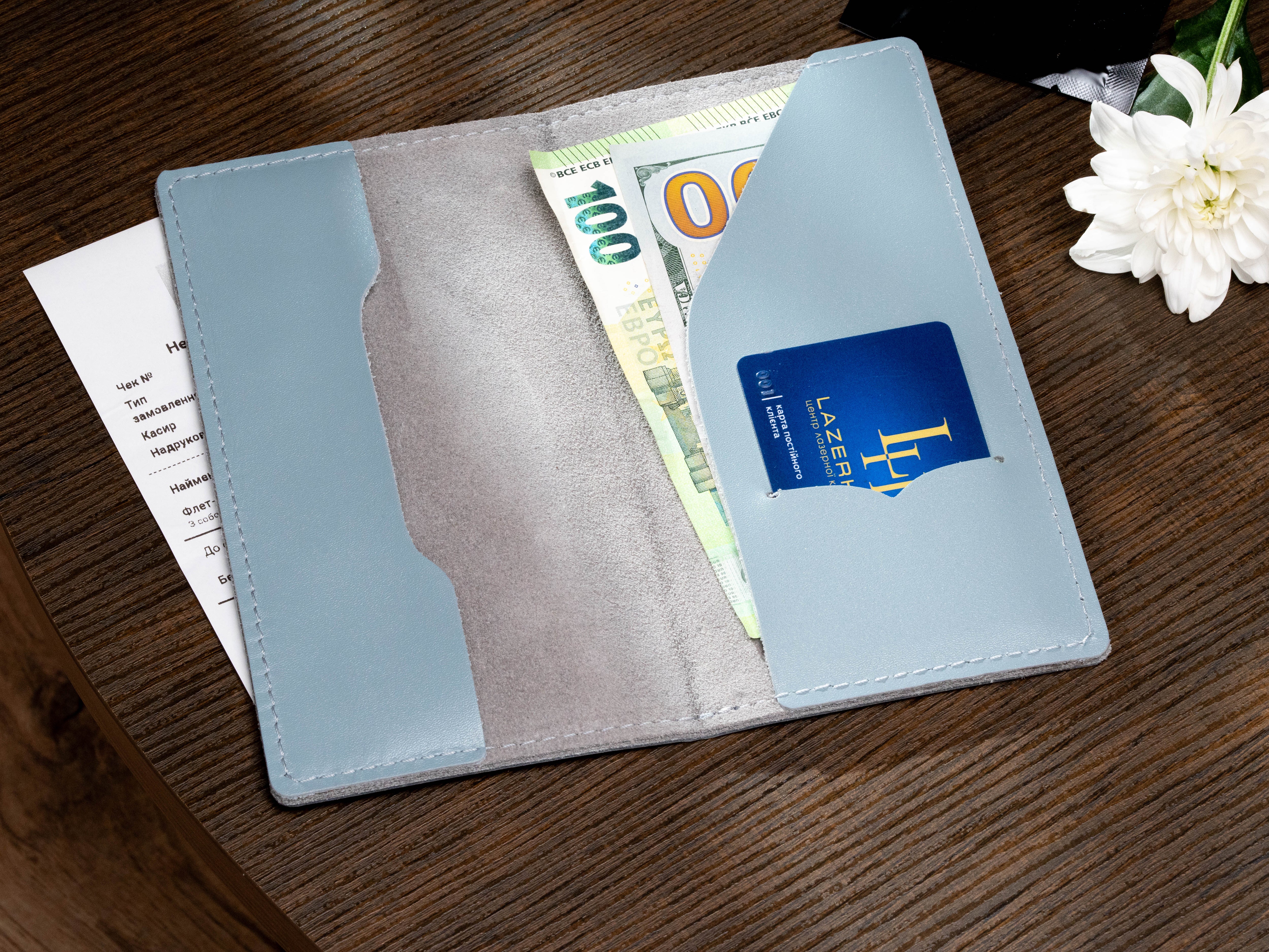 Open ice blue leather payment folder with receipt, euro bills, cash pocket and payment card slot