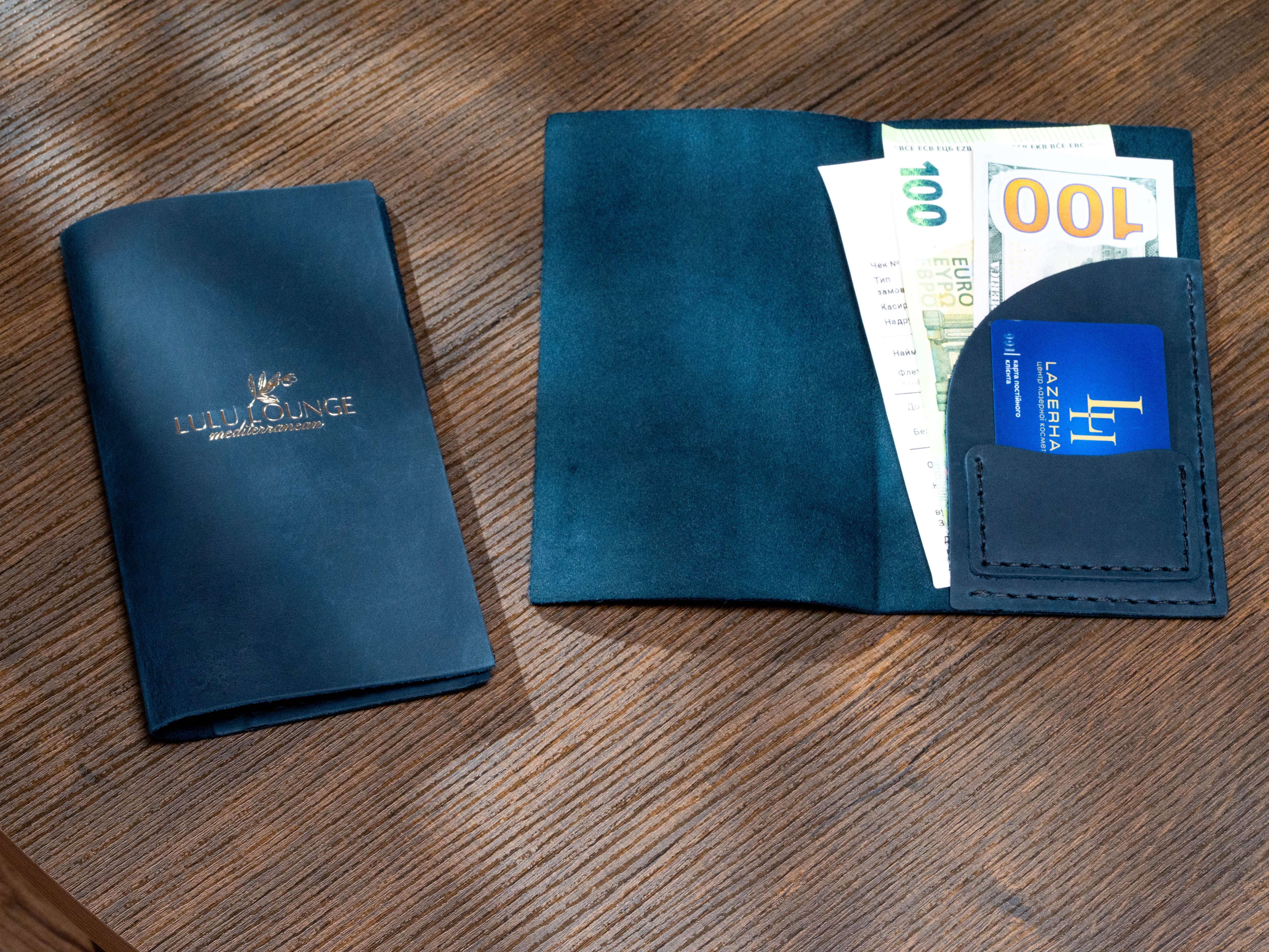 Navy leather restaurant check presenter shown open and closed with gold logo, receipt pocket and card slot