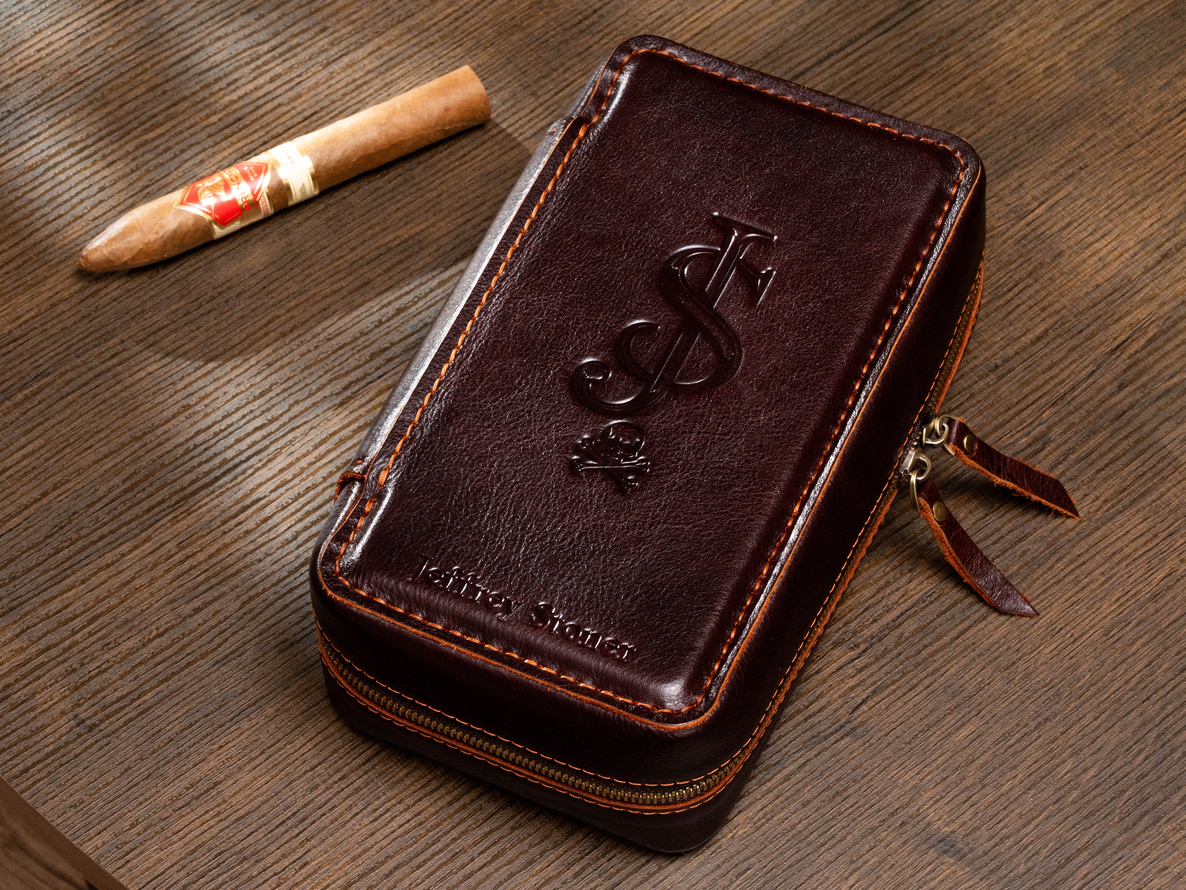 Custom monogram dark brown leather cigar case with contrast stitching shown beside a cigar