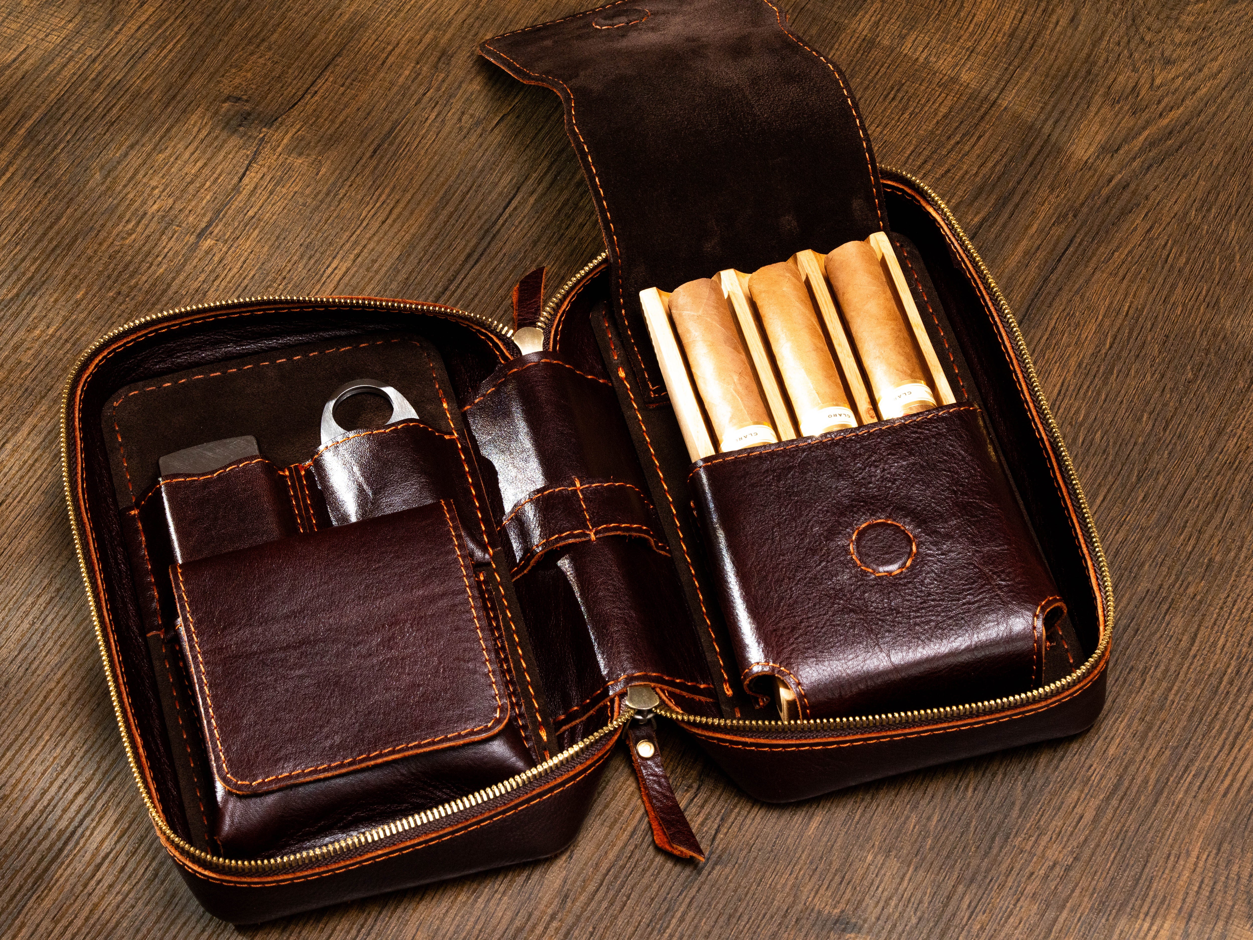 Dark brown leather cigar travel case with removable solid oak tray holding three cigars and accessory storage
