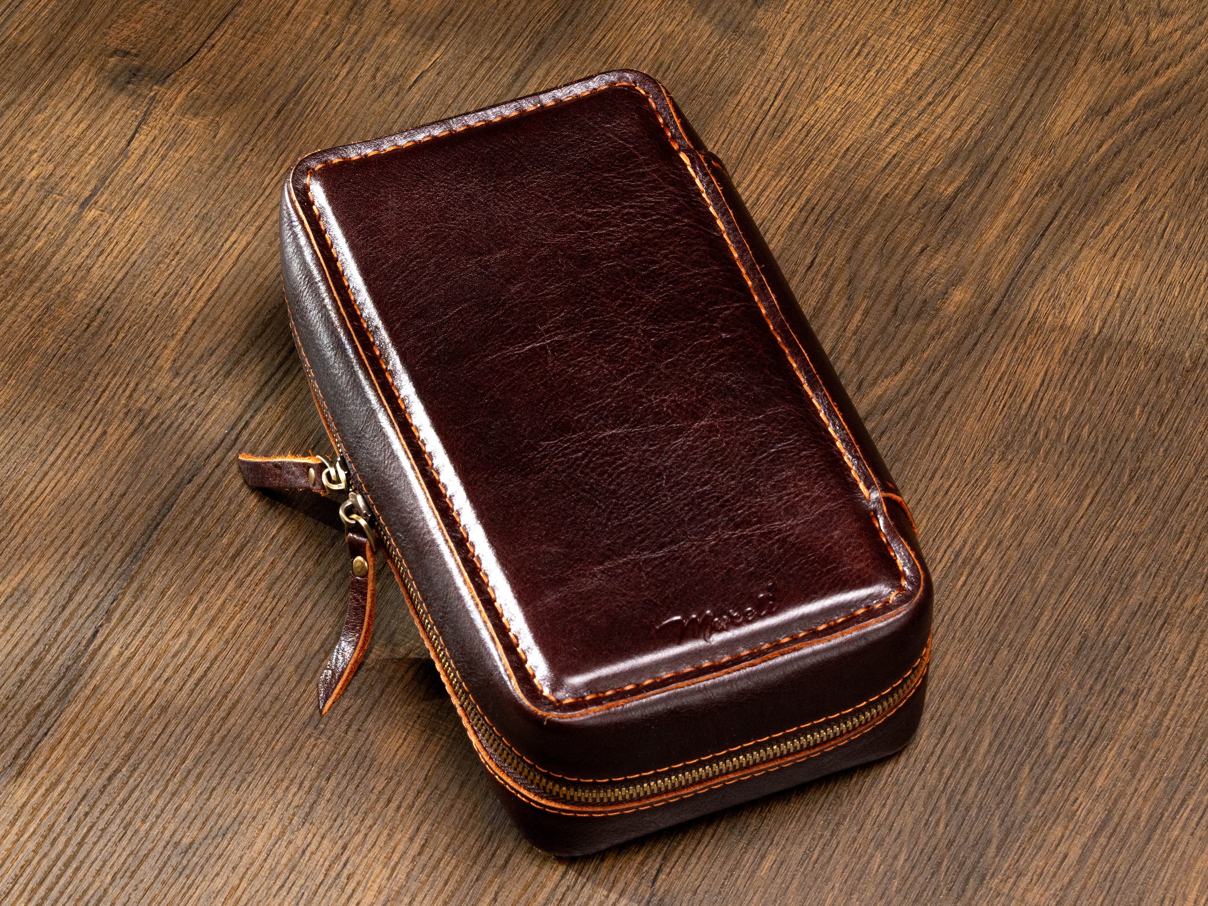Back view of dark brown leather cigar travel case with contrast stitching and metal zip-around closure