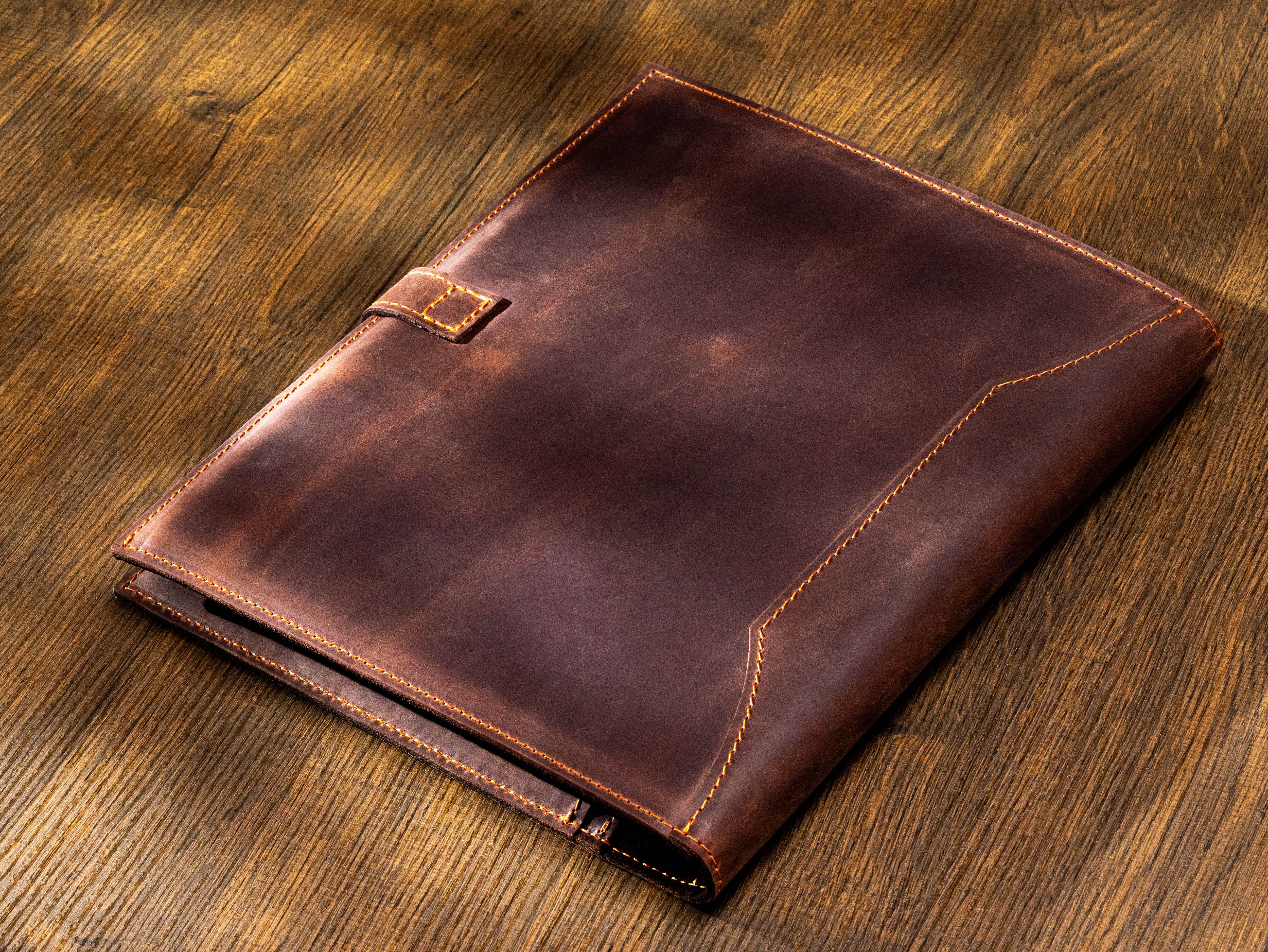 Back view of dark brown leather executive portfolio with contrast stitching and strap closure