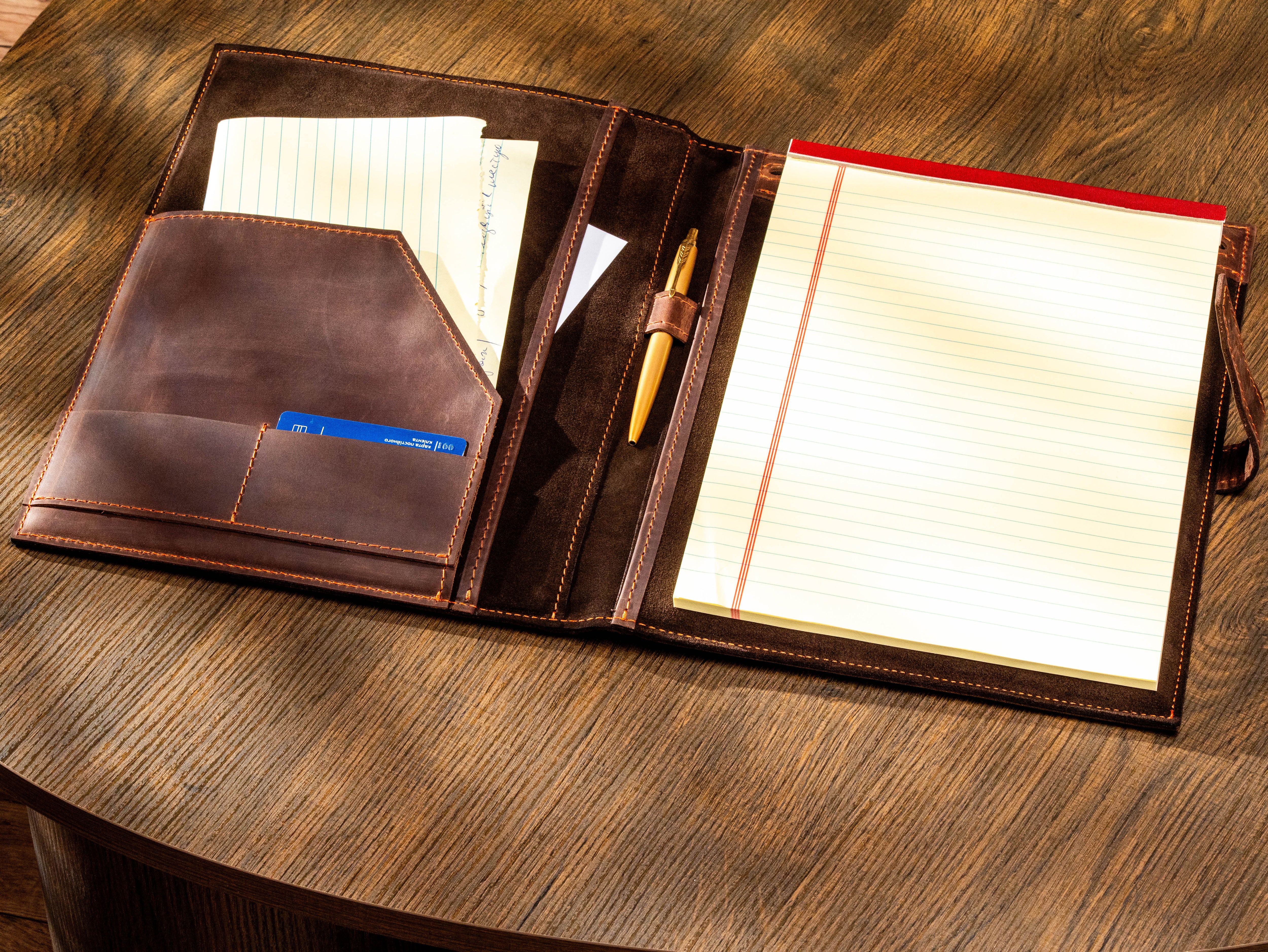 Open dark brown leather portfolio with suede interior, document pockets, card slots and pen holder
