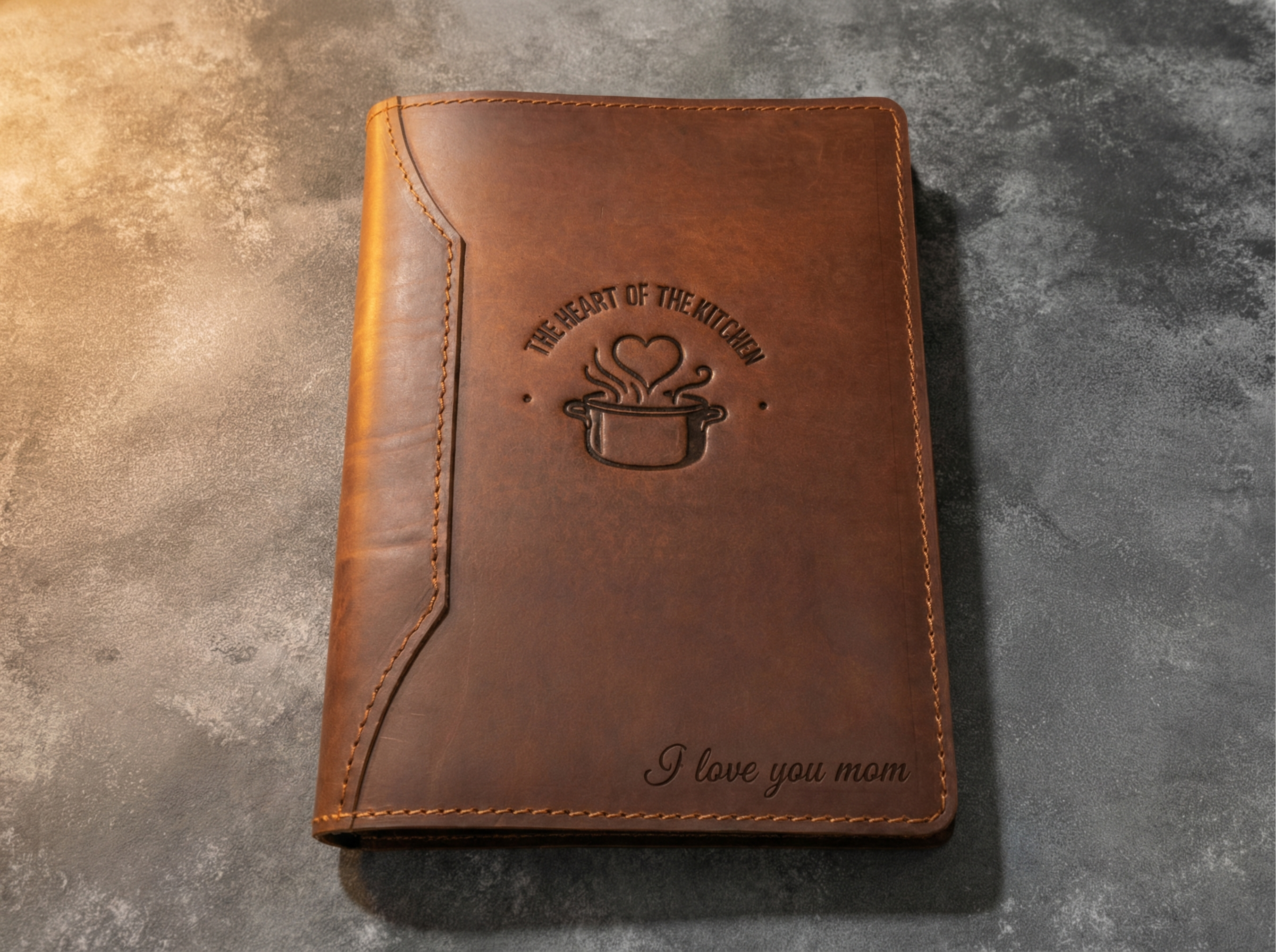 Brown leather notebook with engraved text on a textured surface