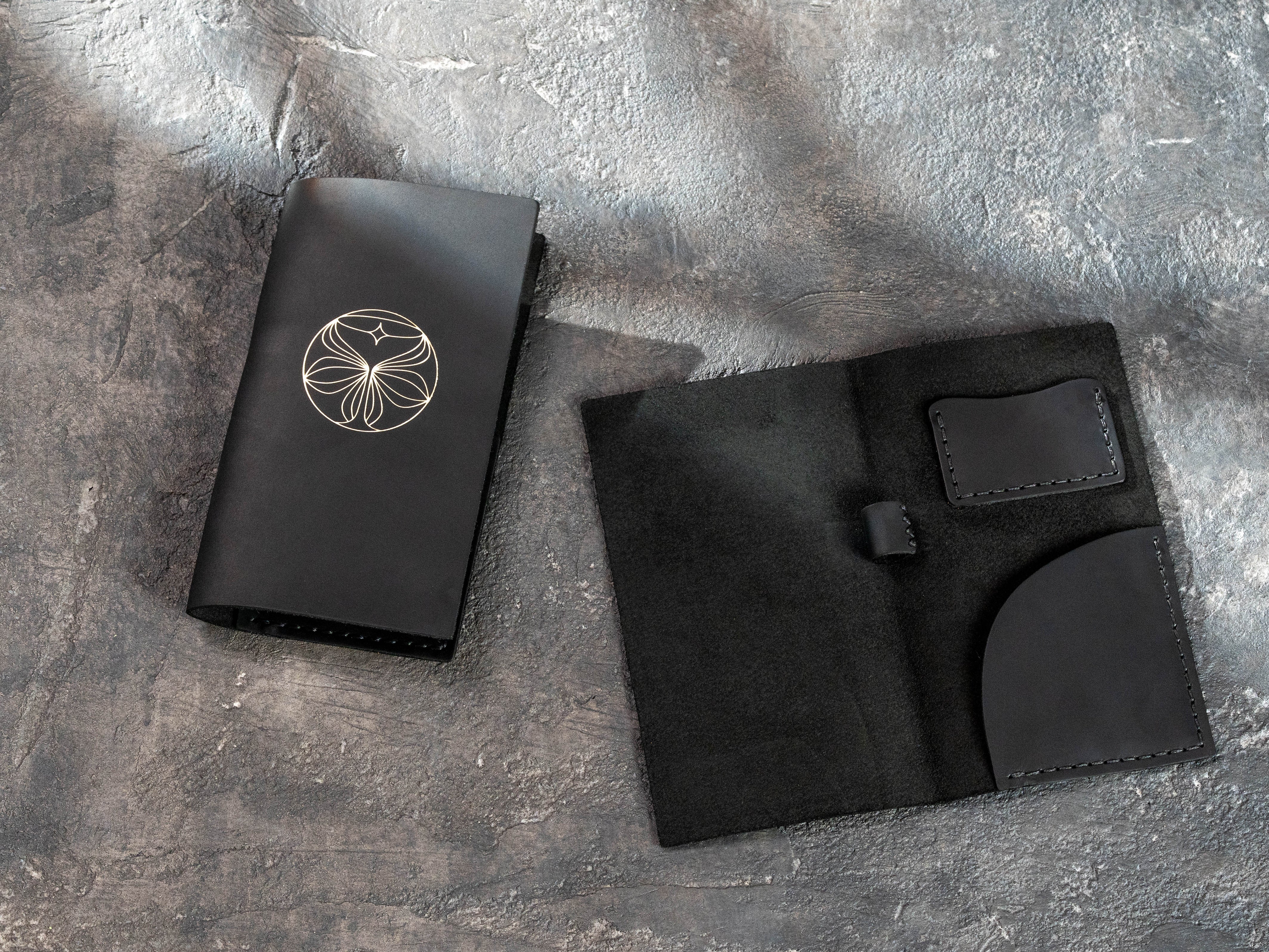 Closed black leather check presenter beside the open Design No. 5 interior with stitched pockets and pen loop