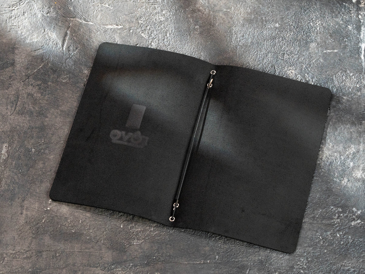 black leather restaurant menu cover showing the central elastic binding