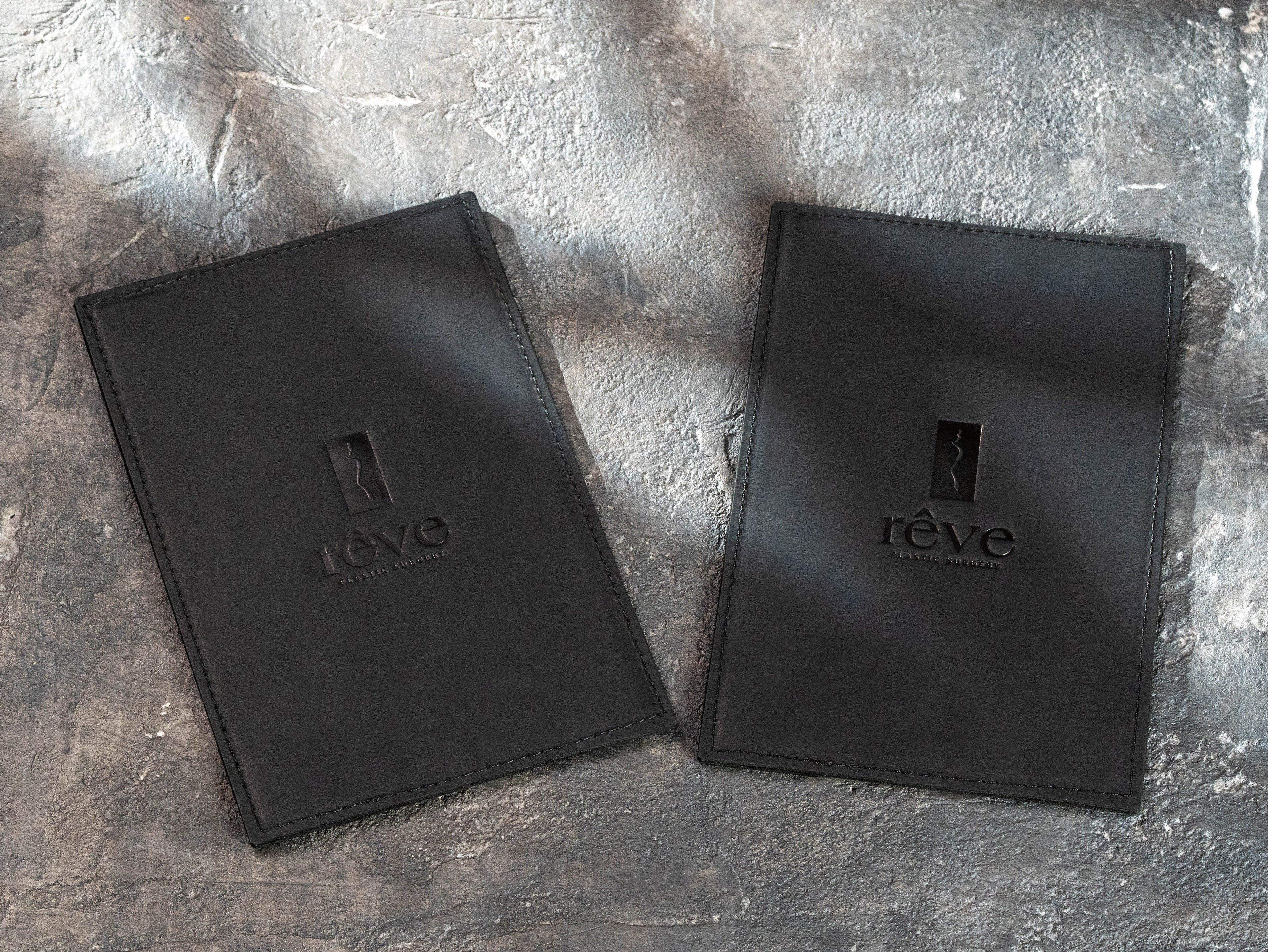 closed black leather restaurant menu boards personalized with embossed Rêve Bistro & Bar logos