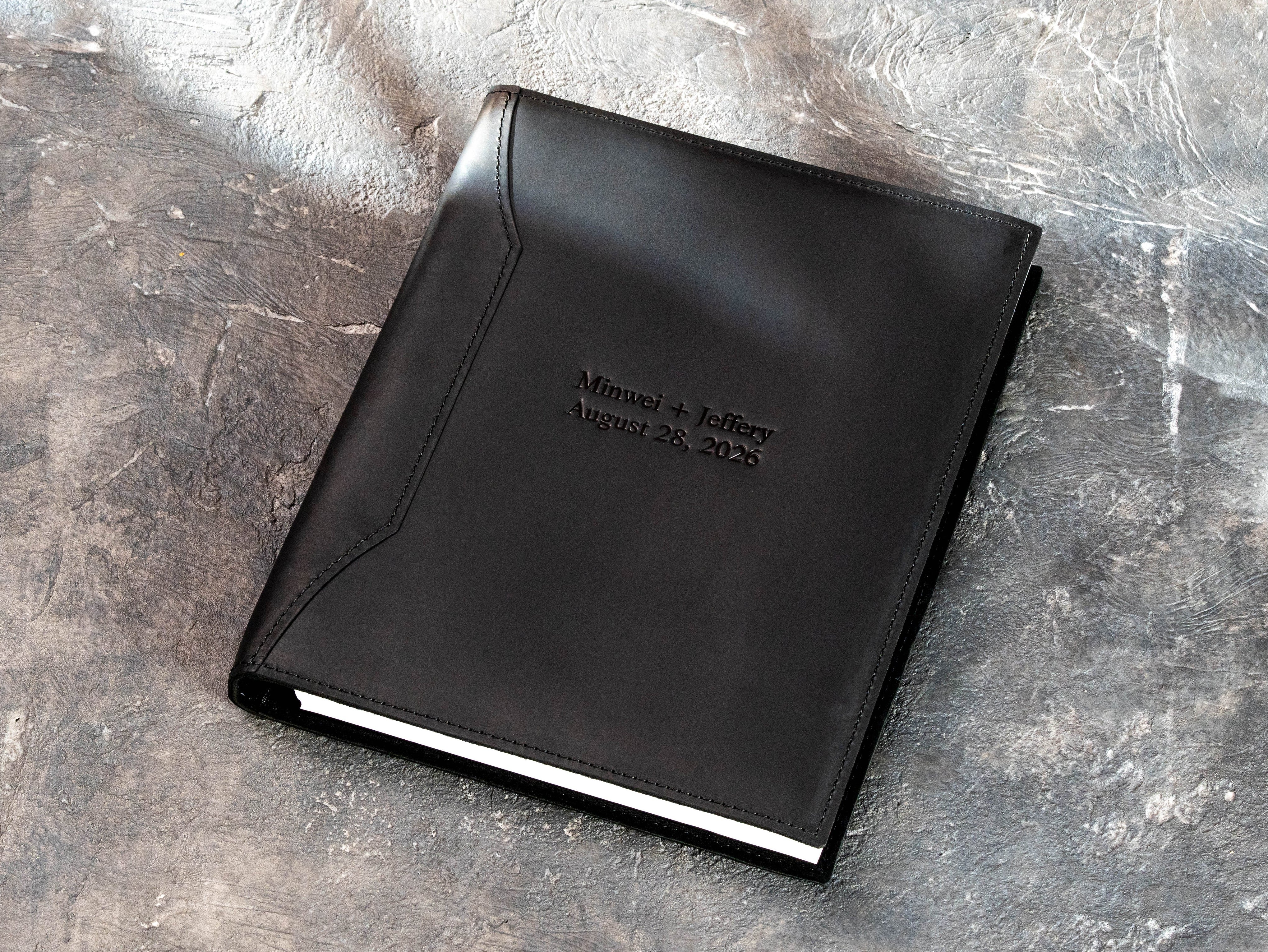 Open black leather wedding binder with soft suede interior and three metal rings