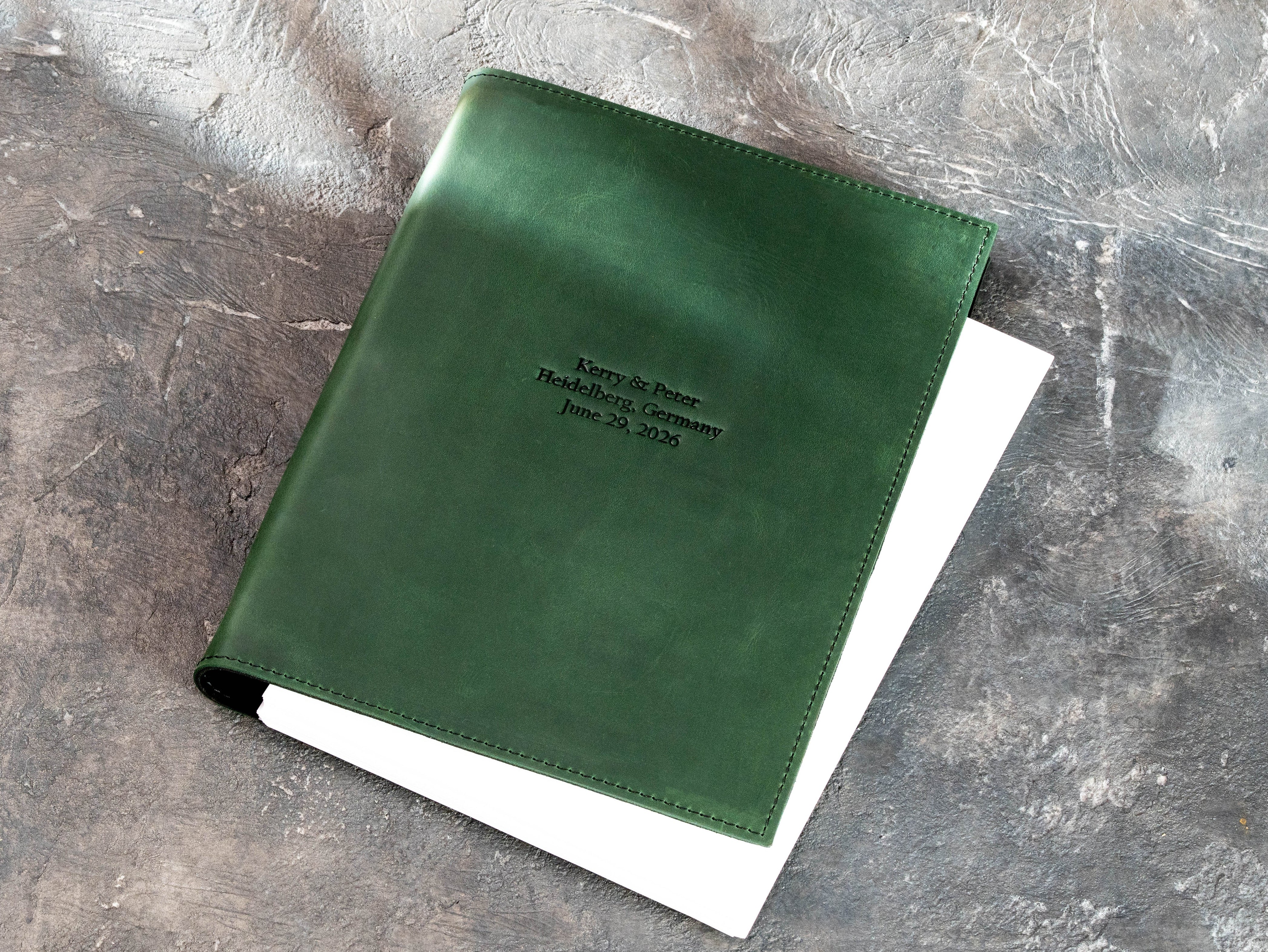 Personalized green leather 3-ring binder with Kerry and Peter names, Heidelberg location, and June 29, 2026 date