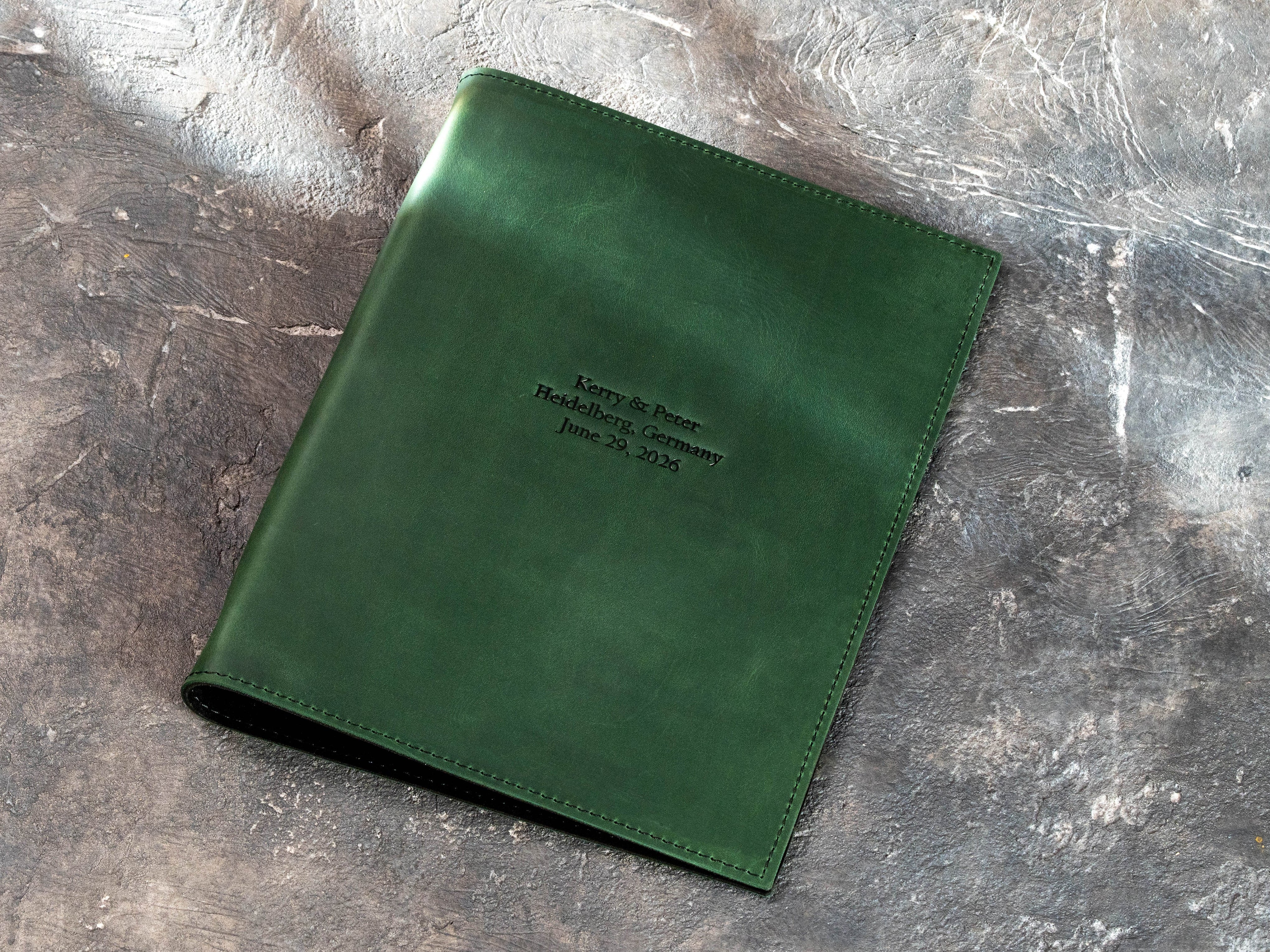 Closed green leather A4 and Letter Size document binder with custom names, location, and date