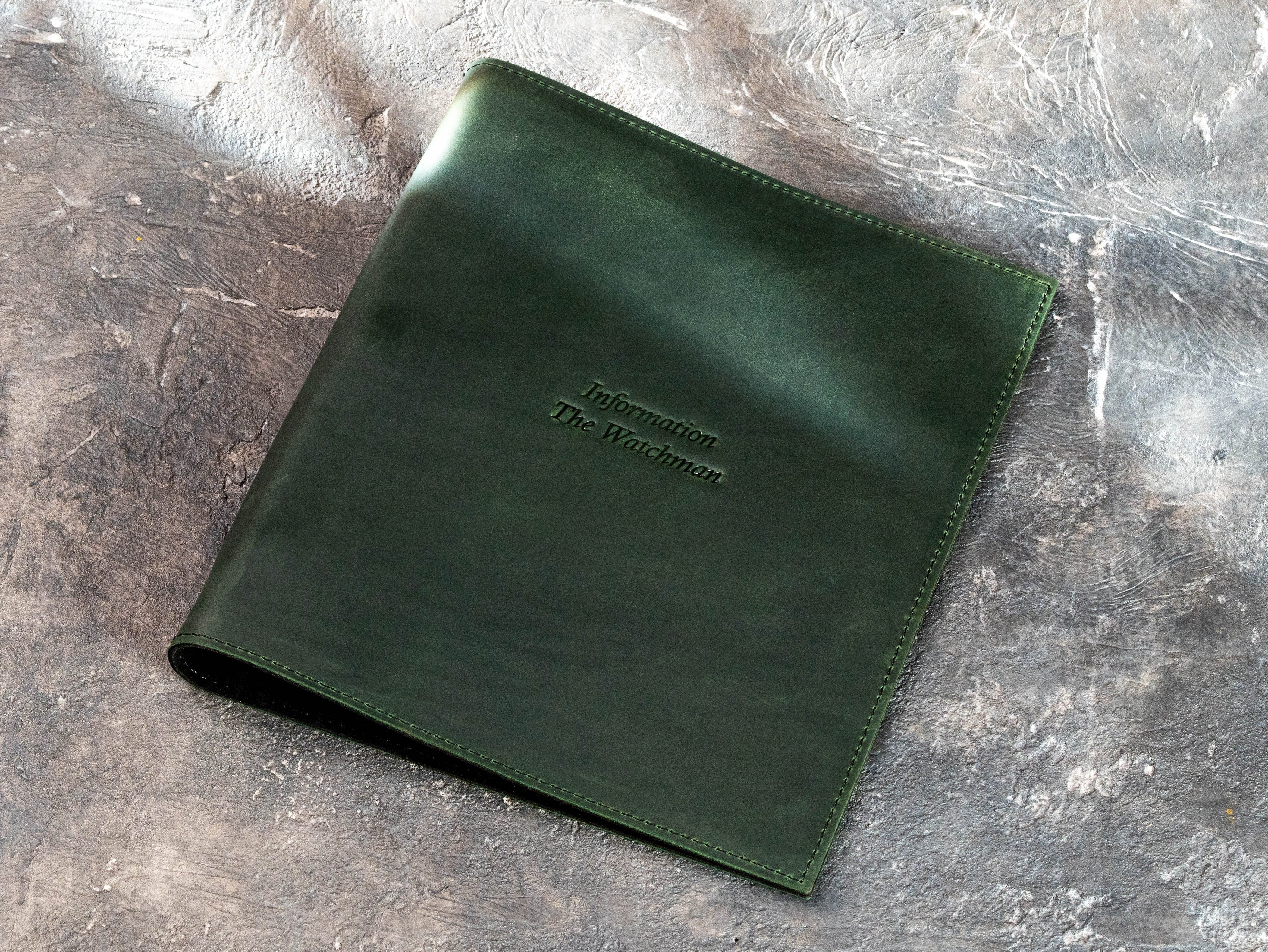 Green leather information binder with custom blind debossed text on the cover