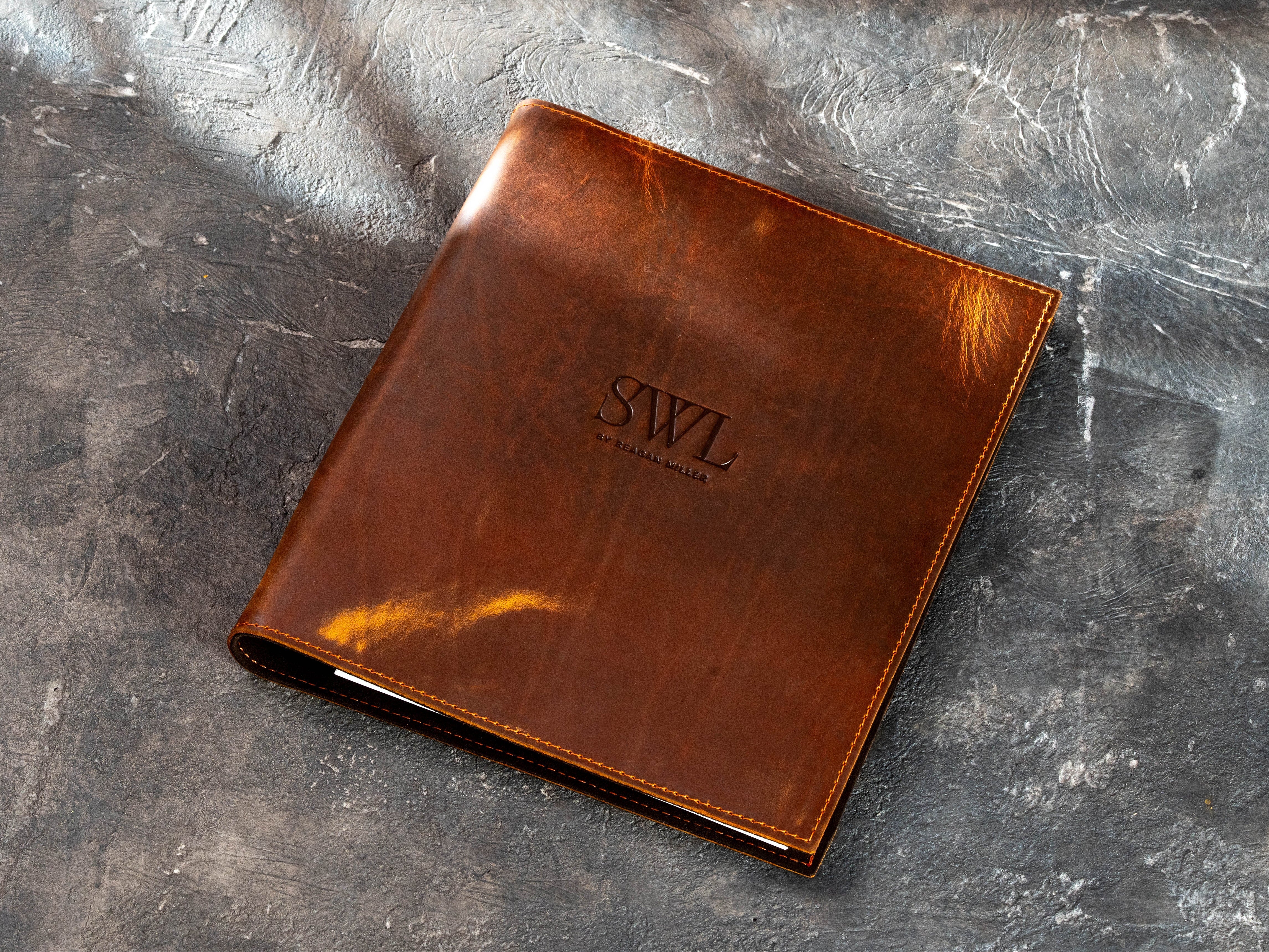 Chestnut leather business binder with custom SWL by Regan Miller embossed logo and stitched edges