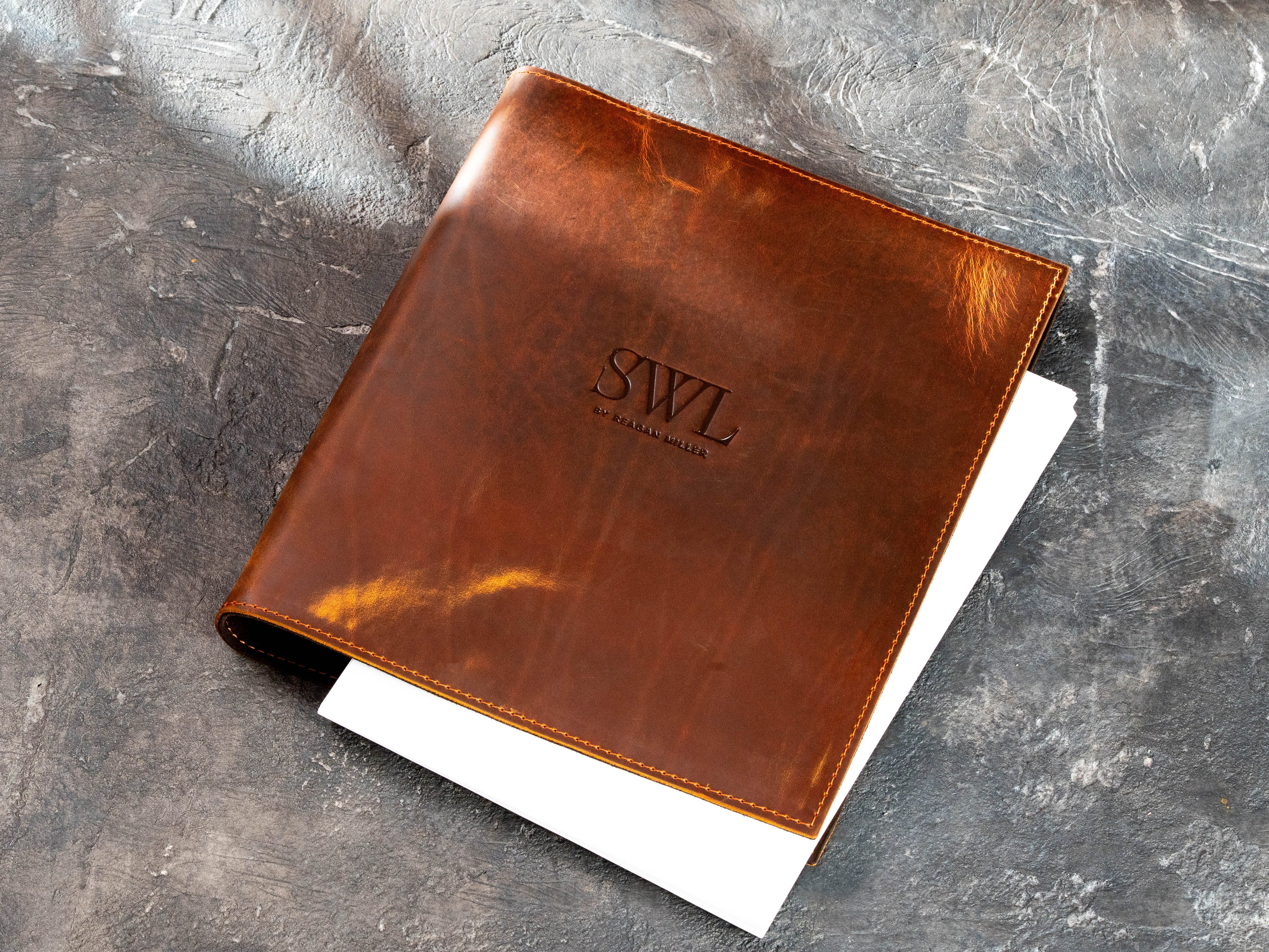 Personalized Chestnut leather 3-ring corporate document binder with white pages visible inside