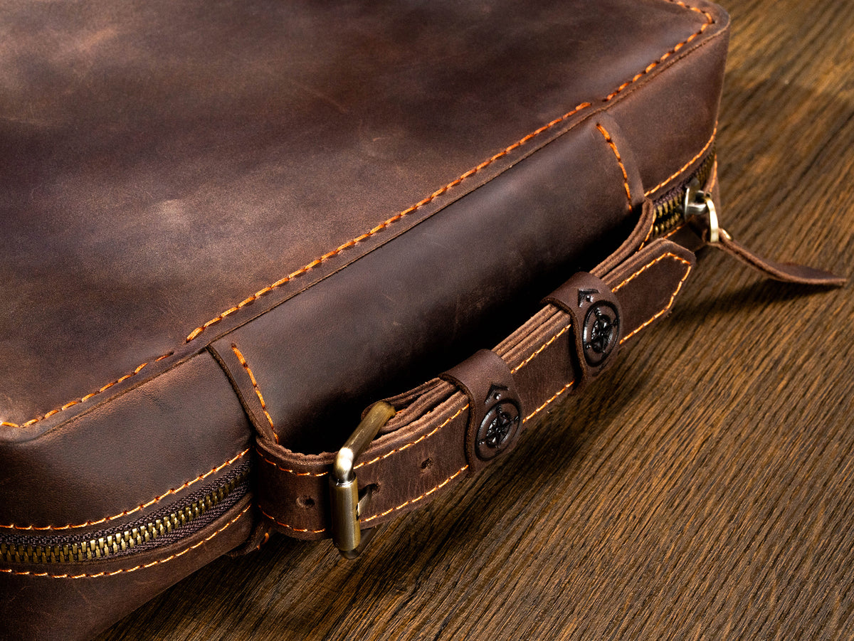 Milk Chocolate Brown leather travel organizer case close-up with belt-style handle, compass details and zip-around closure