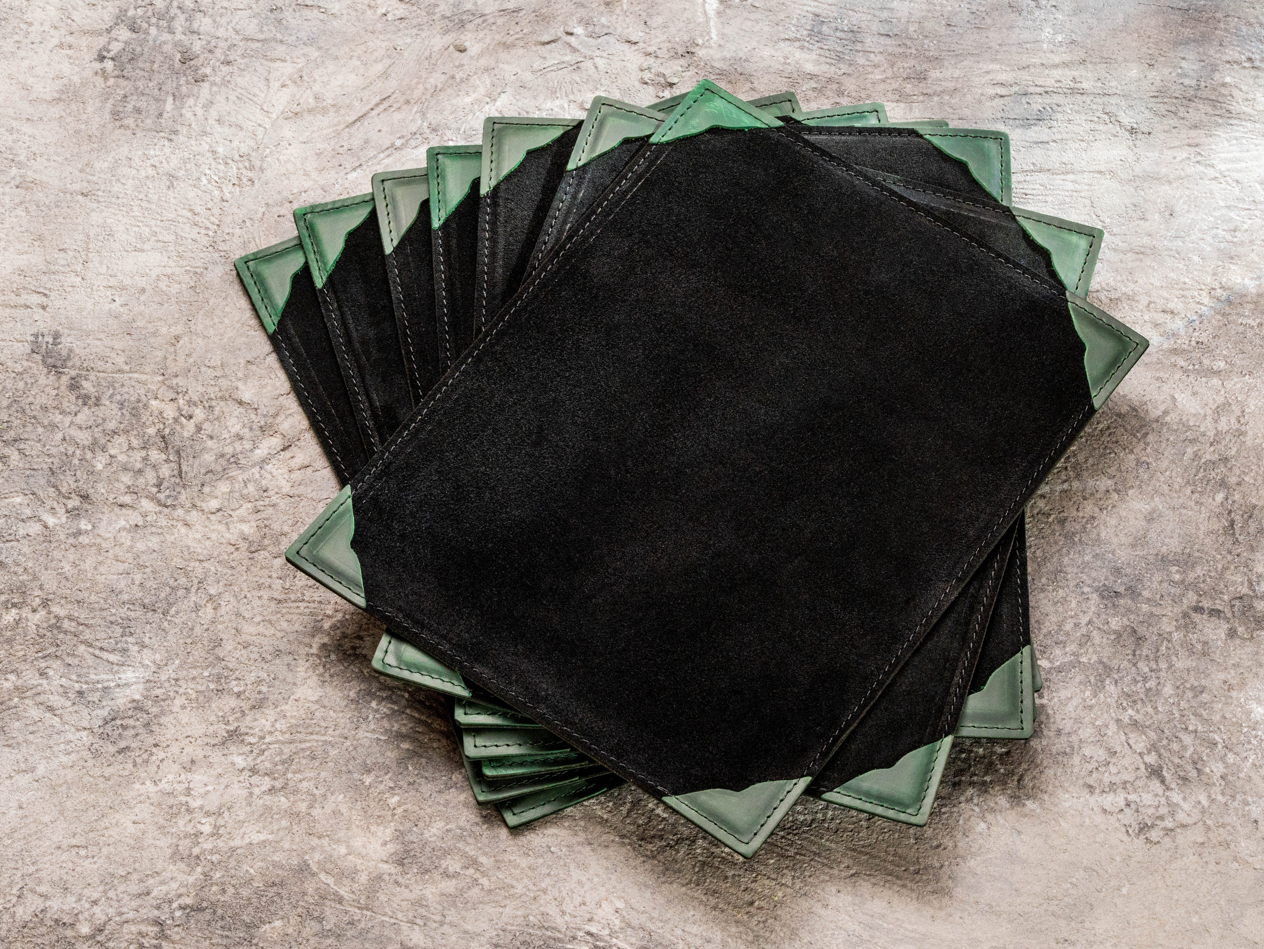 Back view of green and black suede leather restaurant menu boards with reinforced green leather corners