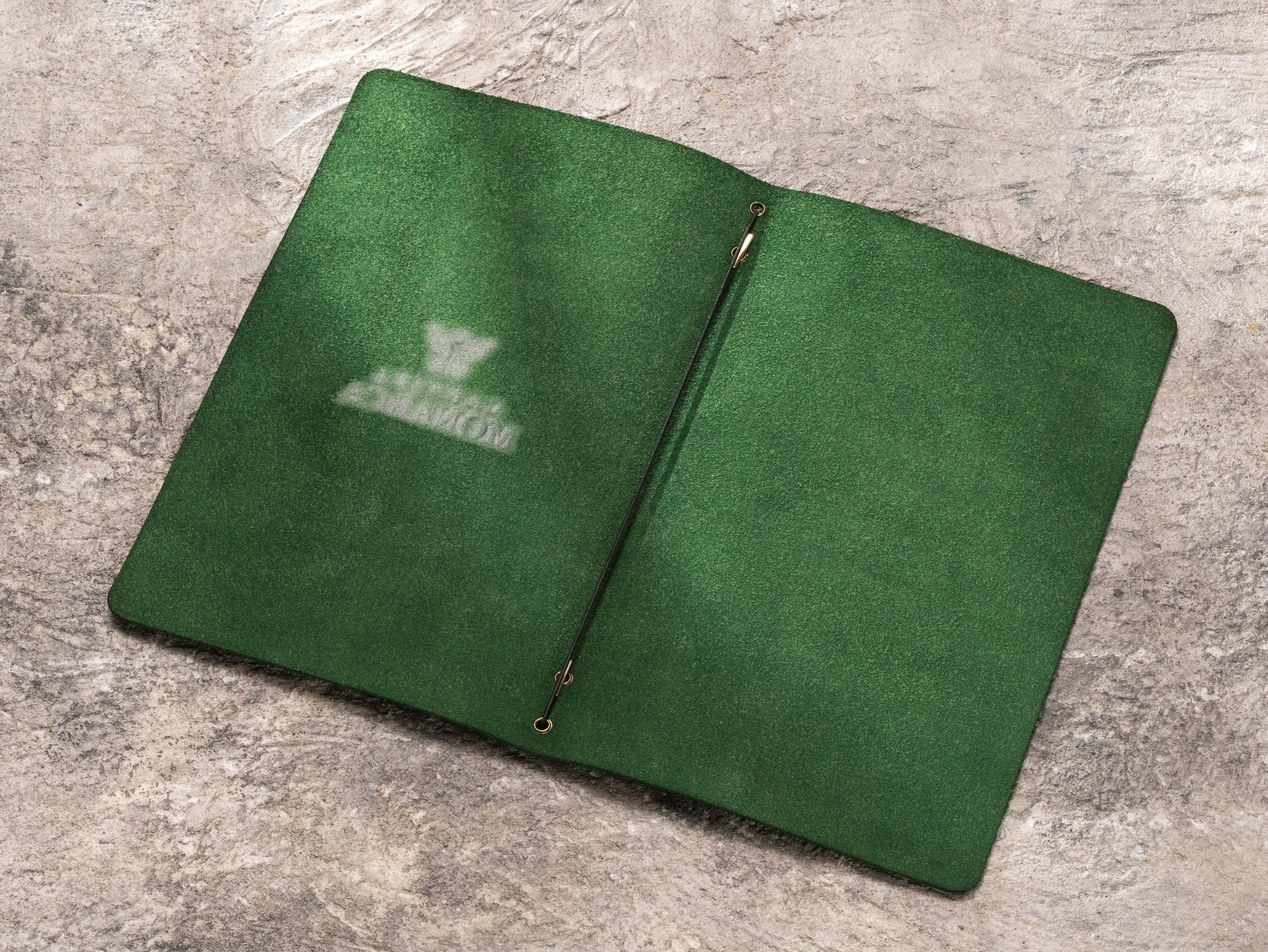 Open dark green leather menu cover with matching green suede leather interior and center elastic cord