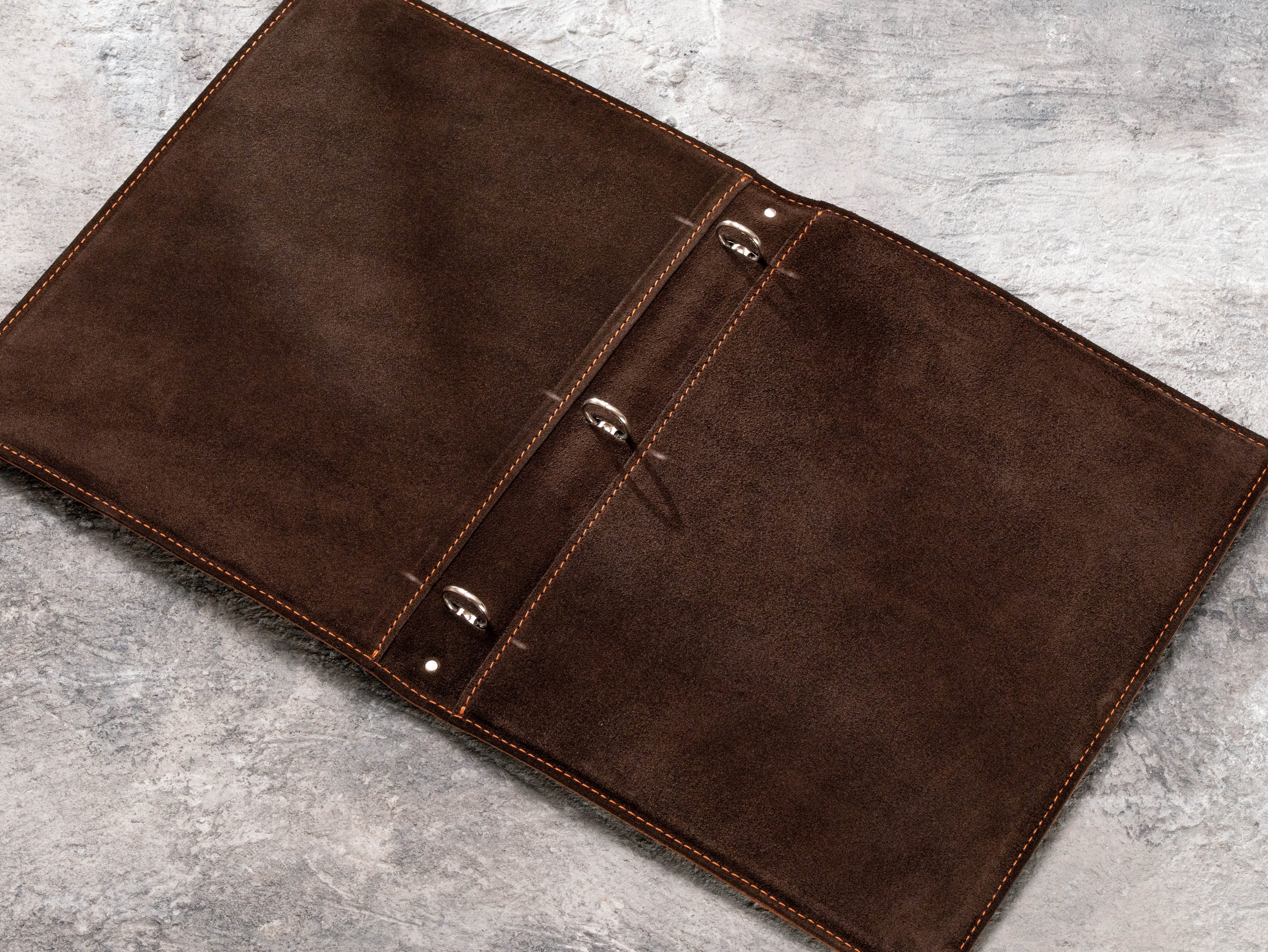Open brown leather healthcare binder with dark suede interior and 3-ring mechanism