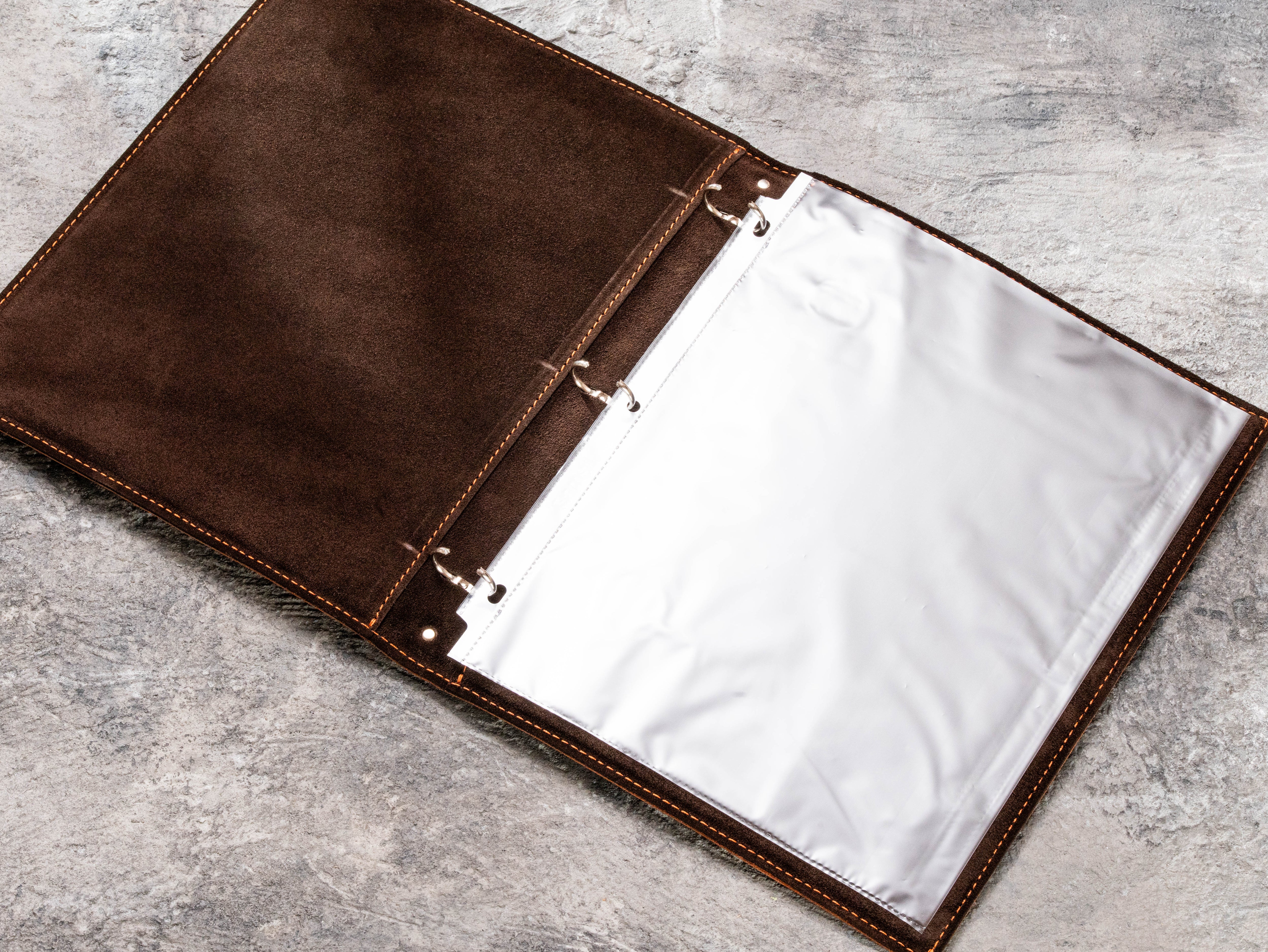 Brown leather medical document binder with 3-ring mechanism and page protector shown