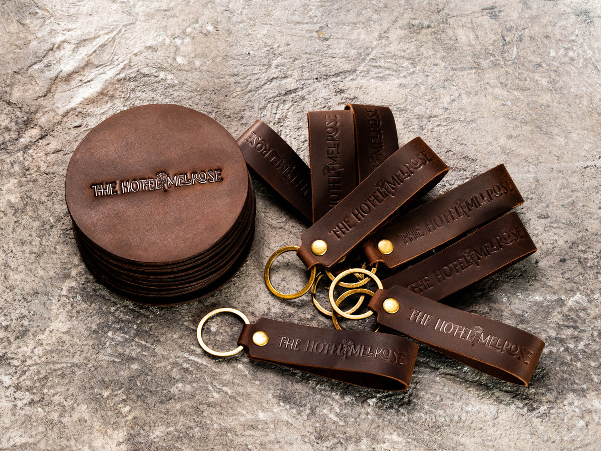 Branded leather hotel keychains and round coasters made for The Hotel Melrose in Grand Junction Colorado
