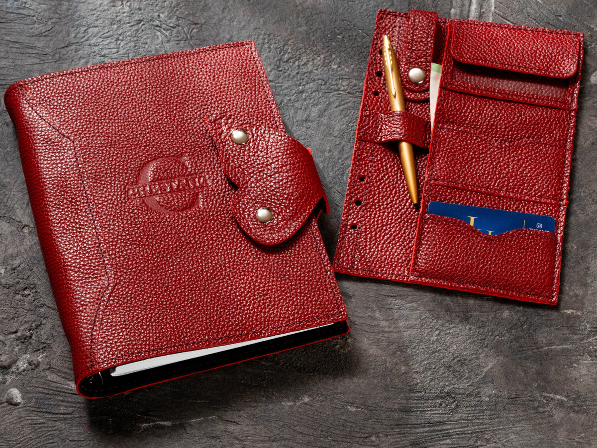 Red Floater leather corporate notebook with butterfly clasp beside removable card pen and document organizer