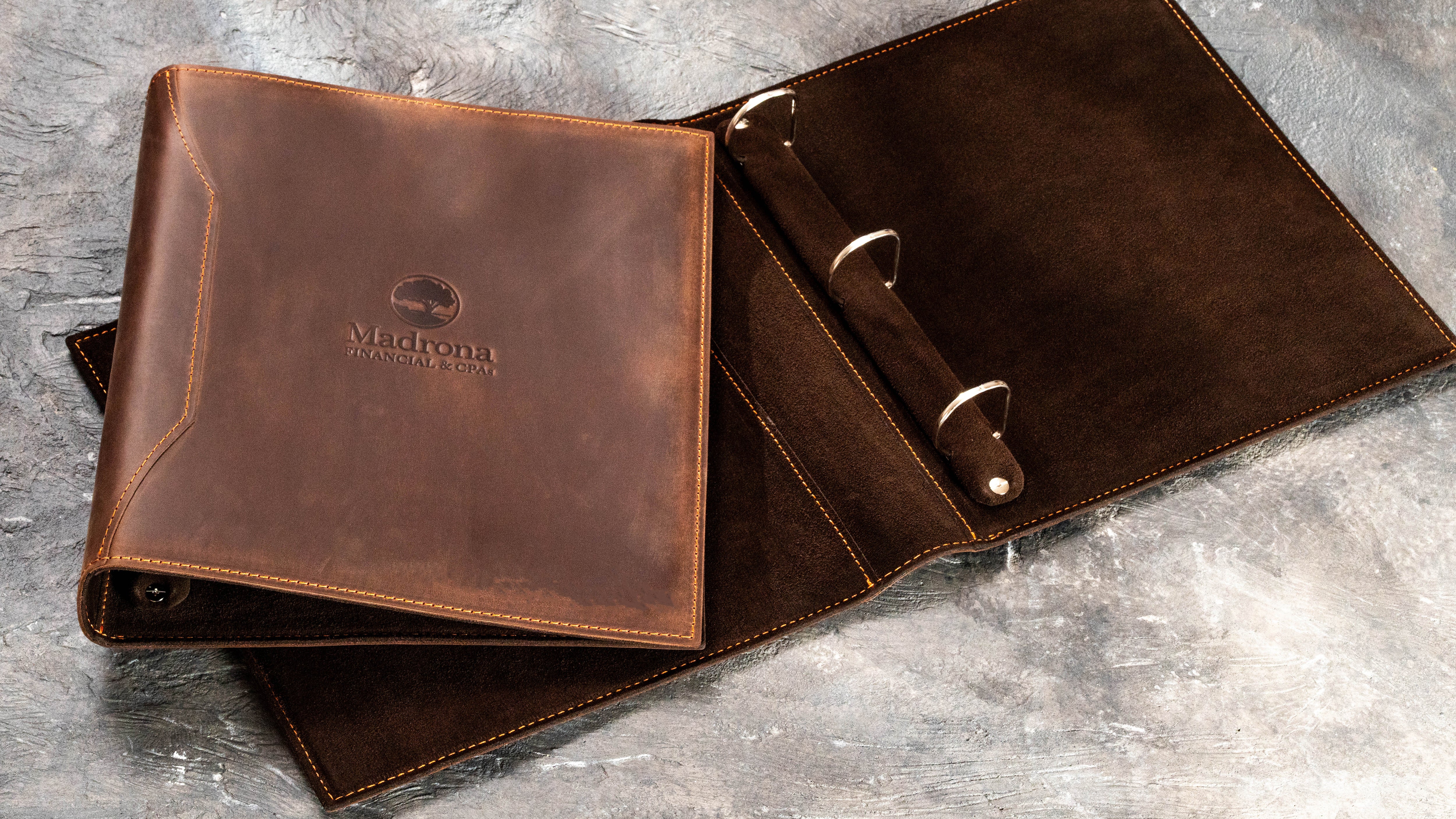 Brown leather 1.5-inch D-ring binder for financial advisors with branded cover and suede interior