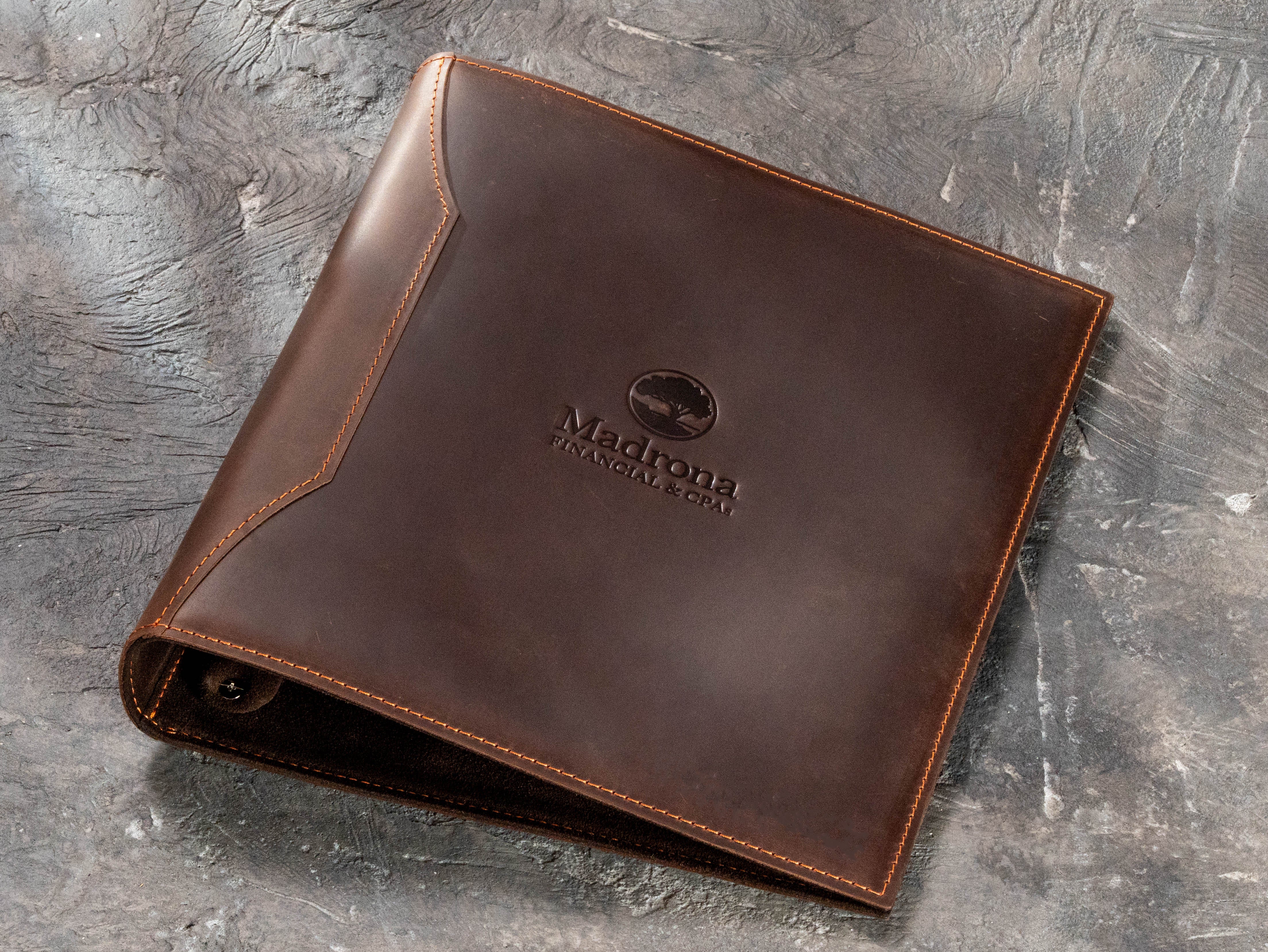 Corporate brown leather document binder with financial company logo and custom employee personalization