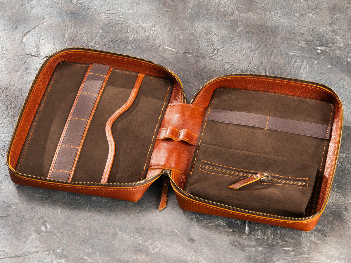 Open Camel leather travel organizer showing flat pocket, elastic holders, suede interior and inner zip pouch