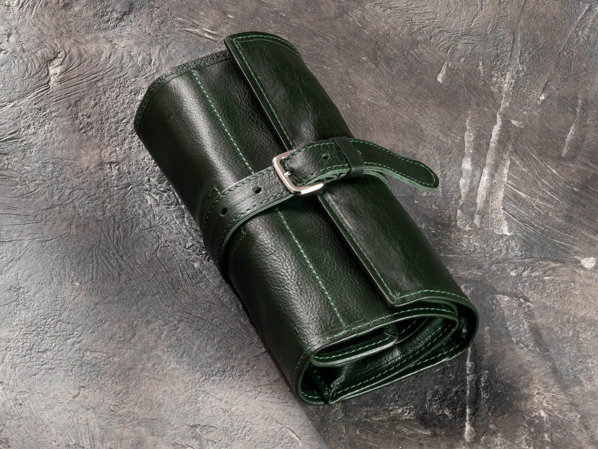 Closed Dark Green leather roll-up travel organizer with adjustable buckle strap