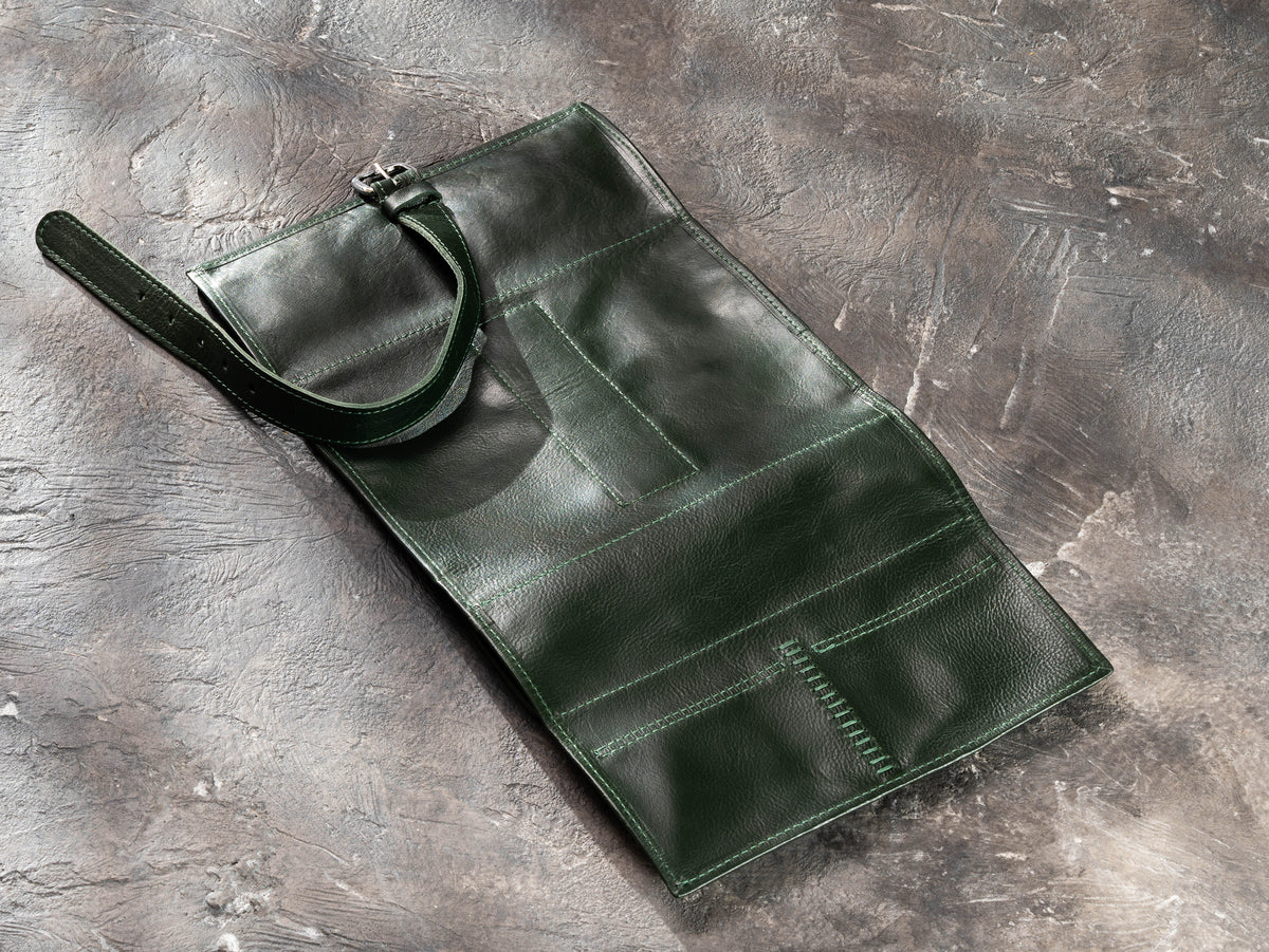 Dark Green leather travel organizer opened flat showing exterior, buckle strap and reinforced hand stitching