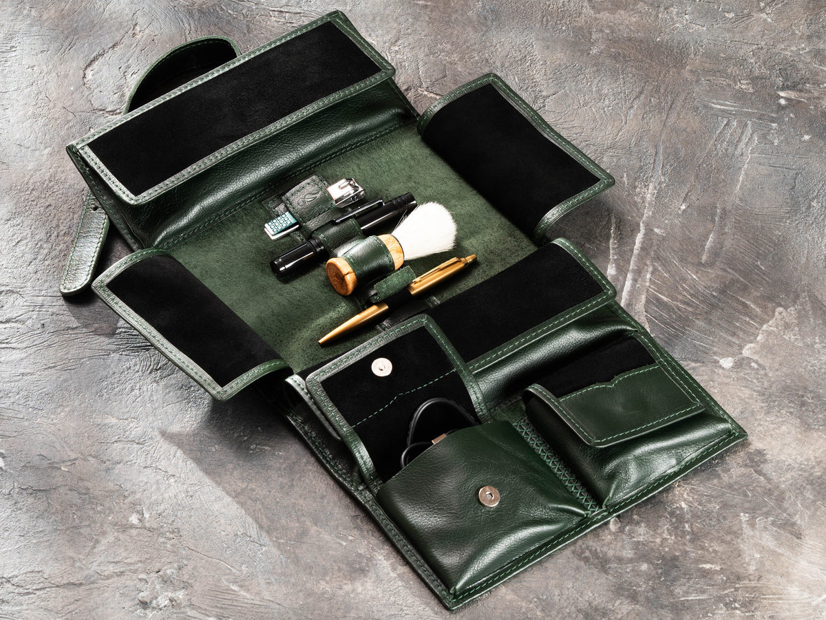 Dark Green roll-up leather travel organizer fully opened with elastic holders and travel accessories