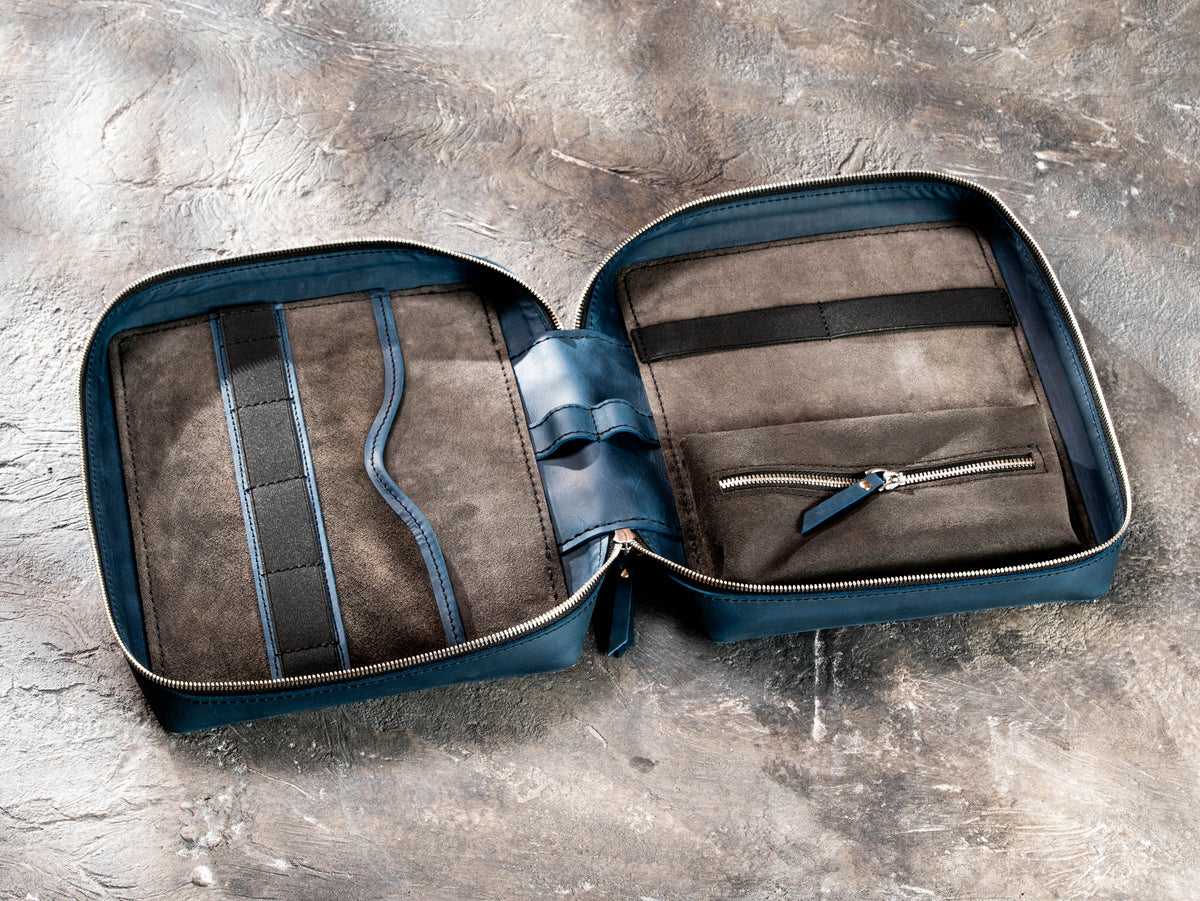 Open Deep Blue leather travel organizer showing flat pocket, elastic holders, suede interior and inner zip pouch