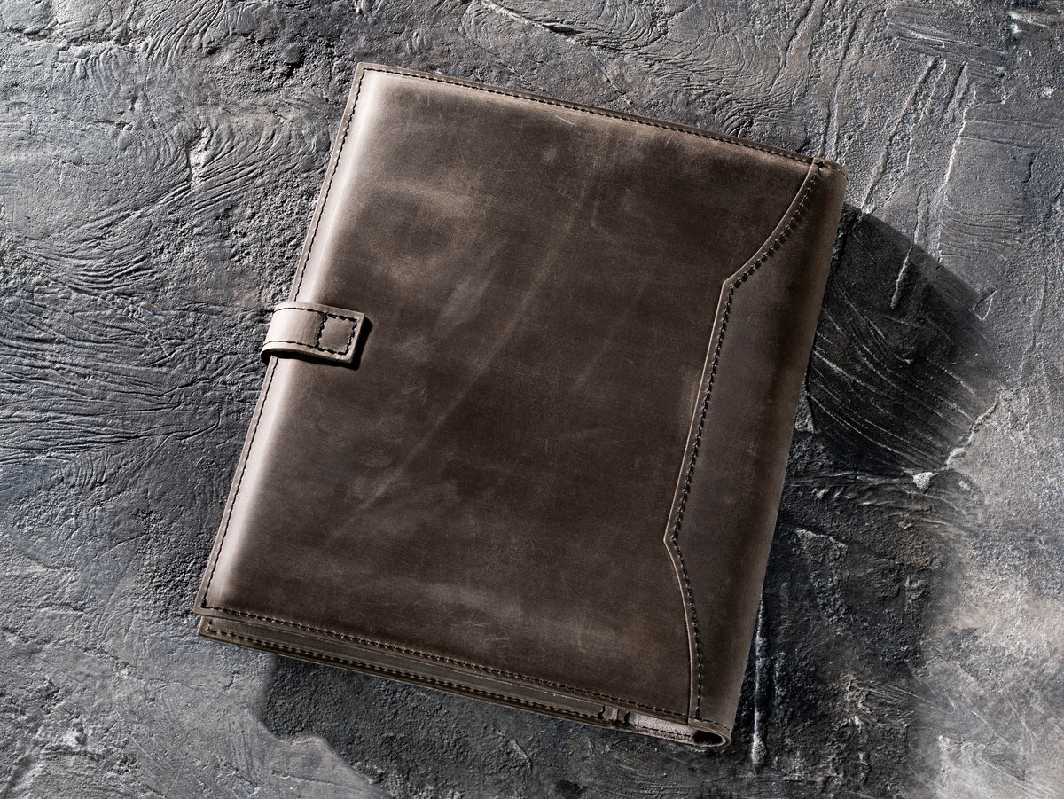 Back view of Gray Crazy Horse leather portfolio with stitched edges and strap closure