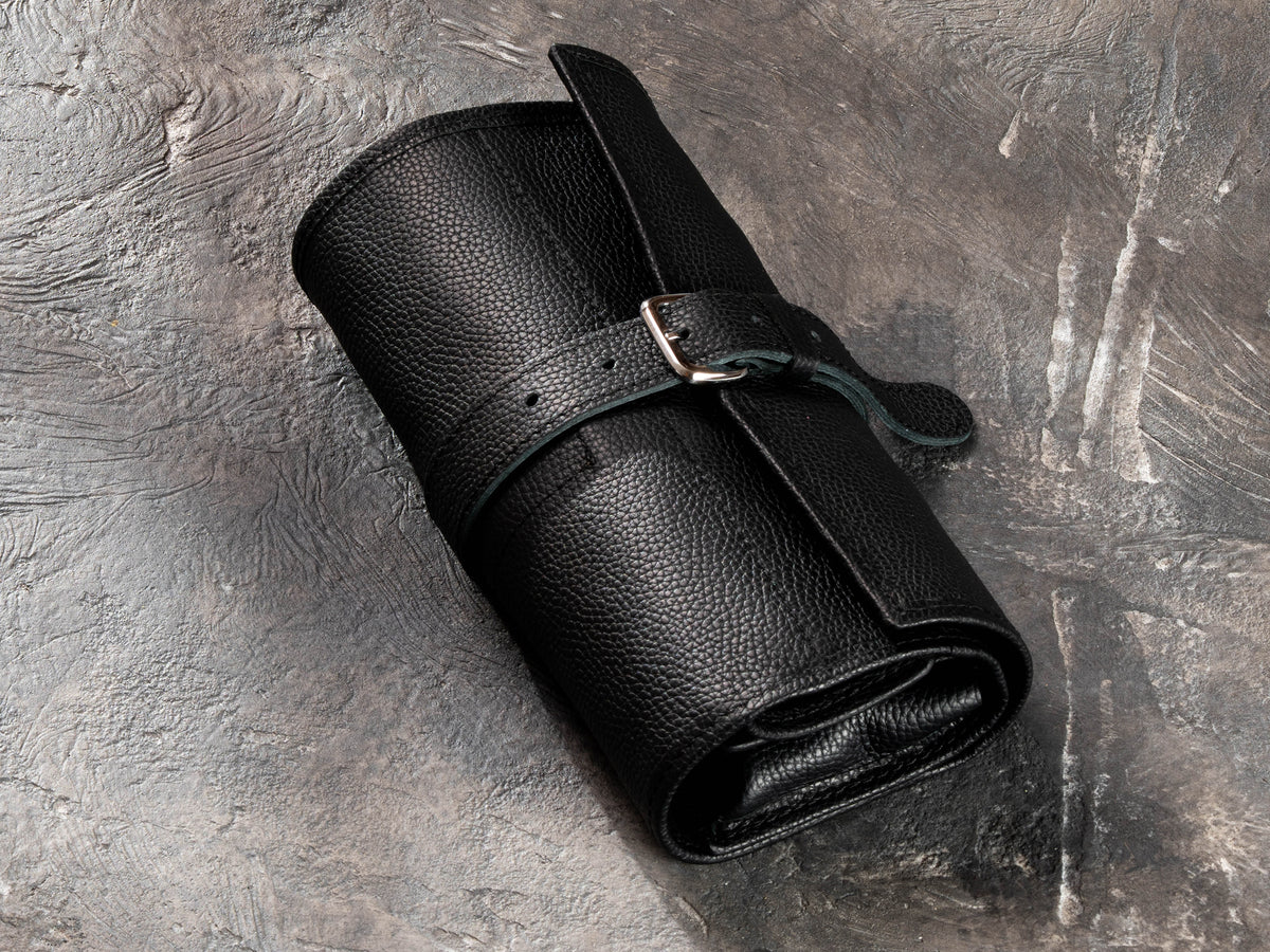 Closed black leather roll-up travel organizer for men with adjustable buckle strap