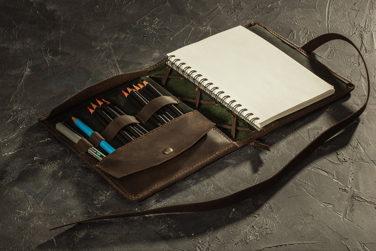 Handmade leather A5 sketchbook organizer showing portrait sketchbook position, pencil holders and western-inspired lacing