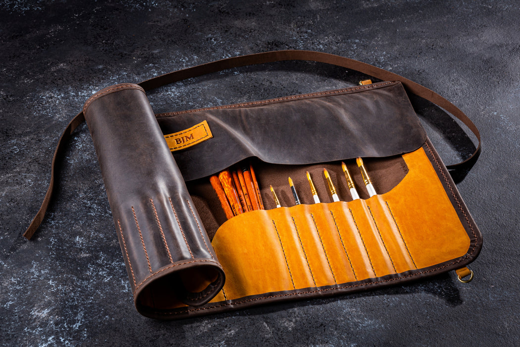 Open tan leather brush roll for artists with suede lining and painting tools